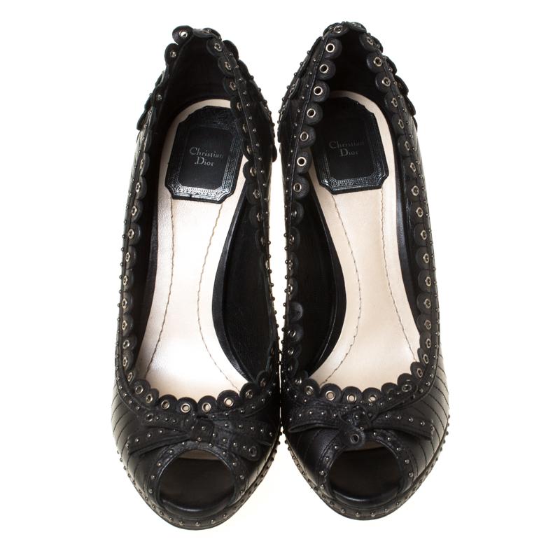 Upgrade your look by adding these Dior pumps to the wardrobe. They are crafted from leather and designed with a textured pattern on th exterior, stud detailing all over, bows on the peep toes and scalloped trims on the topline. Complete with 11.5cm