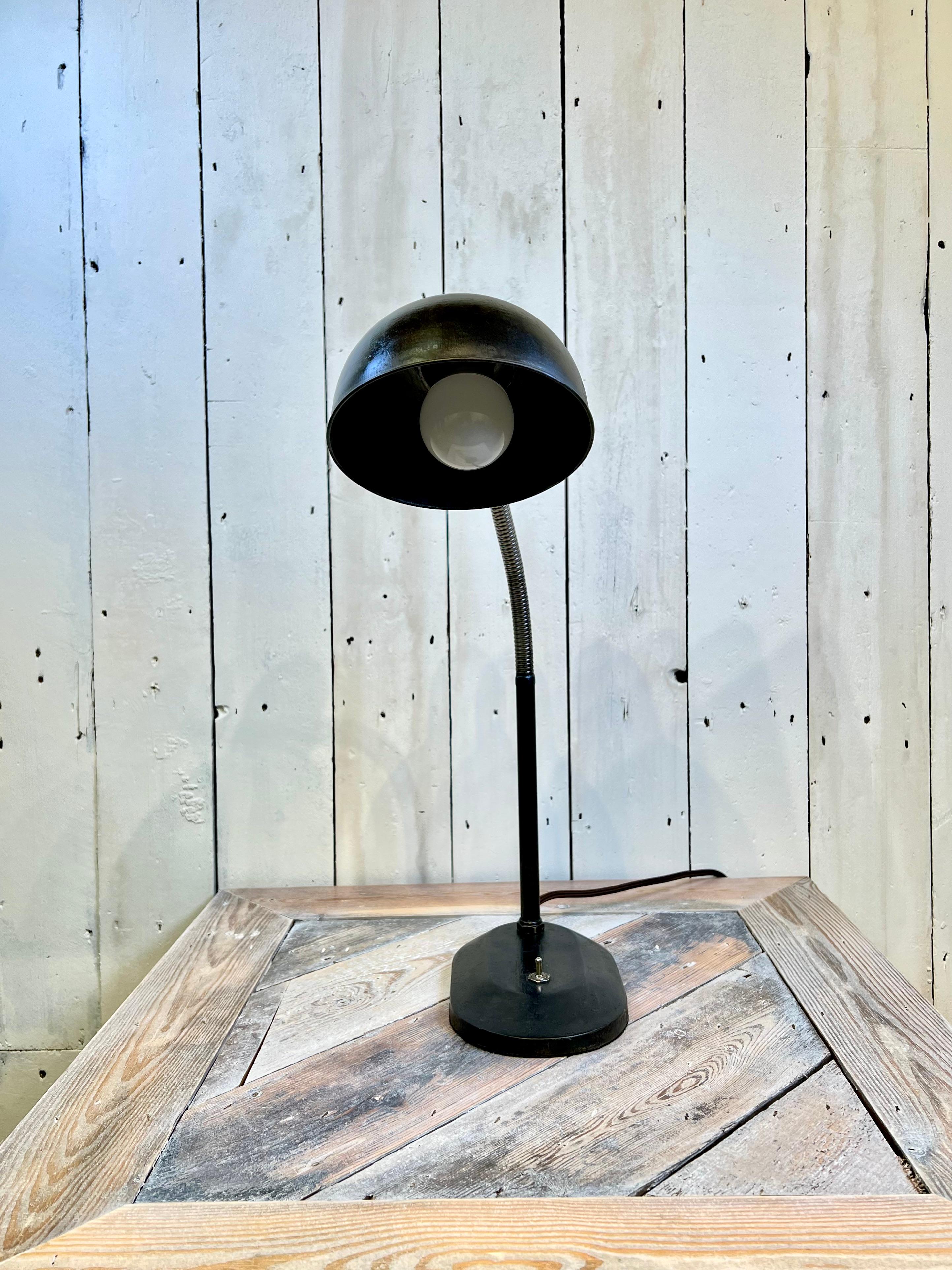 Introduce a piece of timeless design with this 1930's Christian Dell Lighting Design and Bauhaus influenced modernist black desk lamp. The sleek and minimalist silhouette showcases the iconic Bauhaus style, with a sharp geometric form and a bold use