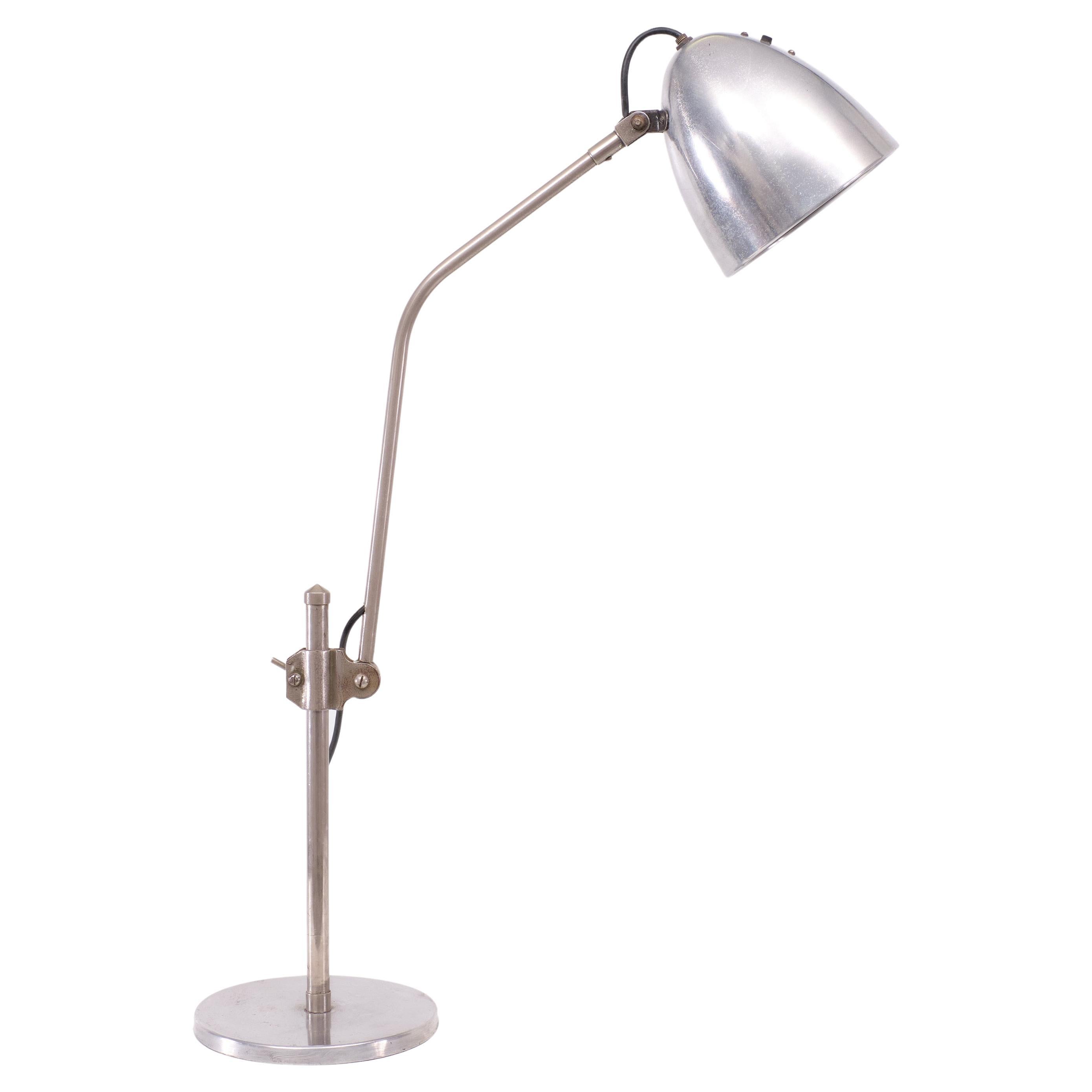A rare early twentieth century task lamp attributed to Bauhaus designer Christian Dell, Aluminum  finish to shade and base. The circular shade pivots on a retractable arm, which in turn can be adjusted at various angles and heights from the base