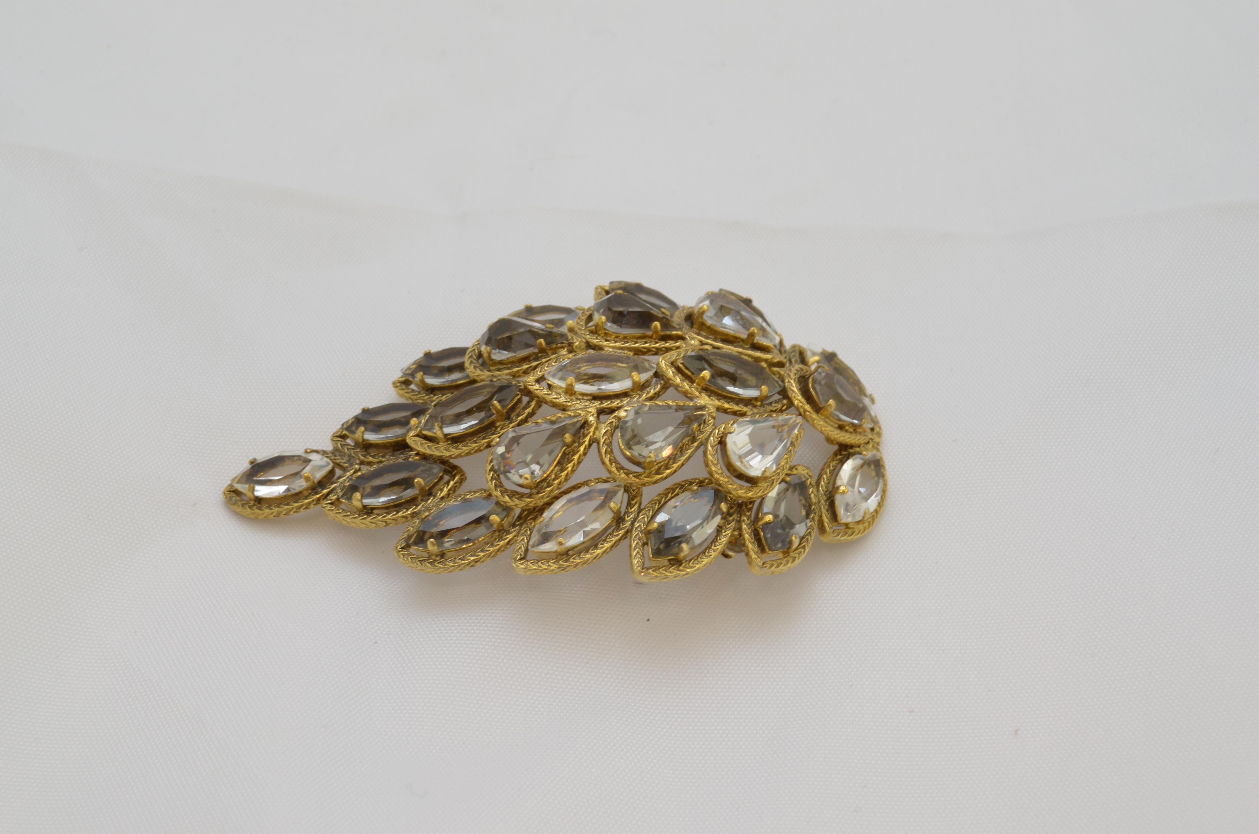 Christian Dior 1962 Vintage Crystal Leaf Brooch featured in a gold-tone metal with faceted crystals. Signed at the back (Chr. Dior 1962). Brooch is in great vintage condition.