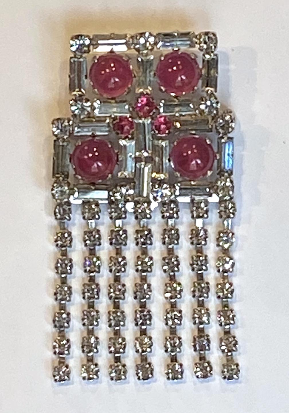 A wonderful eye catching Christian Dior brooch in rhinestone and glass cabochon from 1970. It was made by the company Henkel & Grosse' of Germany who began producing jewelry for Dior in 1955 and continues today. The rhodium plated brooch is set with