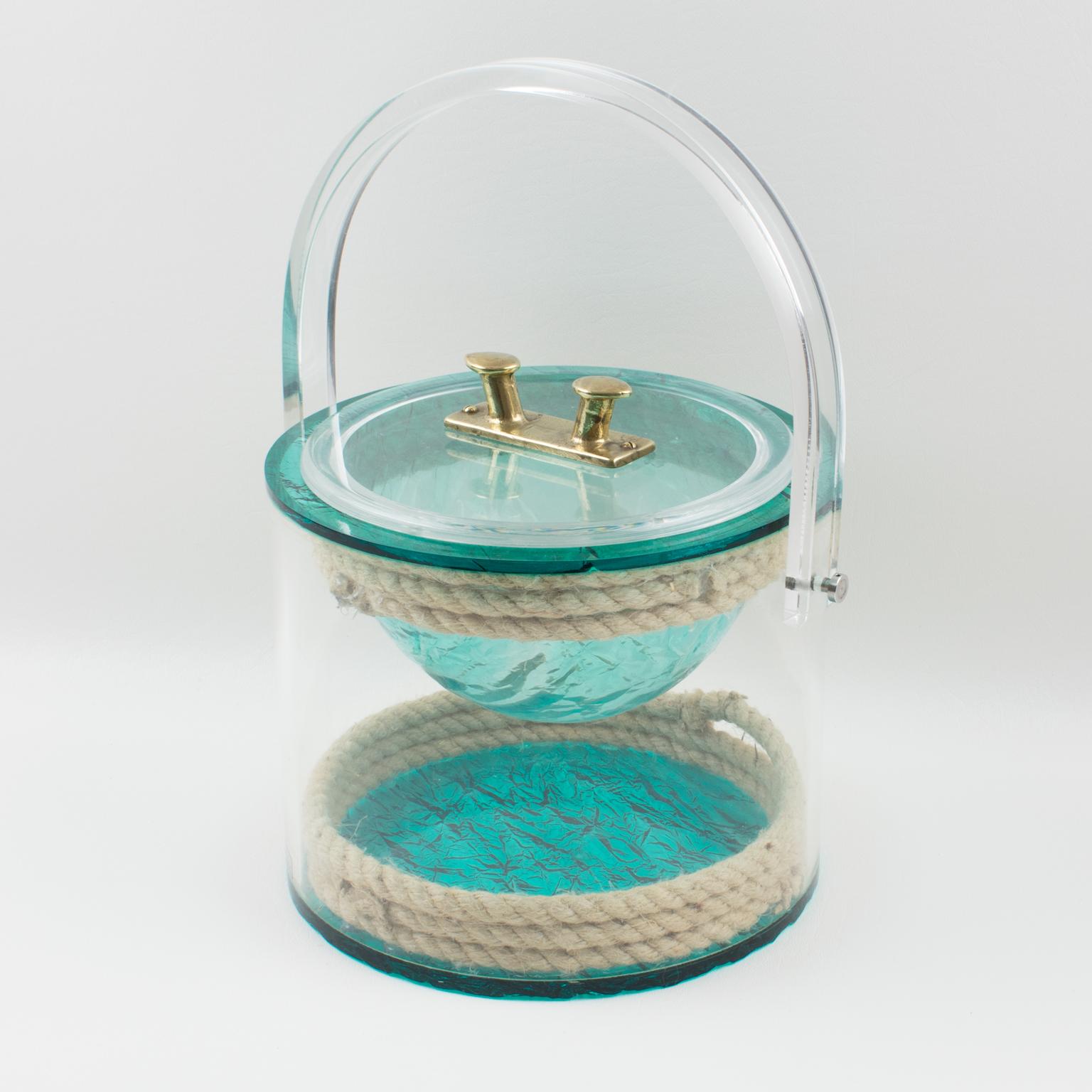 Stunning barware ice bucket designed for Christian Dior home collection, in the 1970s. Rounded shape with tall handle, featuring real rope embedded in the crystal clear Lucite, with a brass metal handle on the lid in a boat-fittings-like shape. The