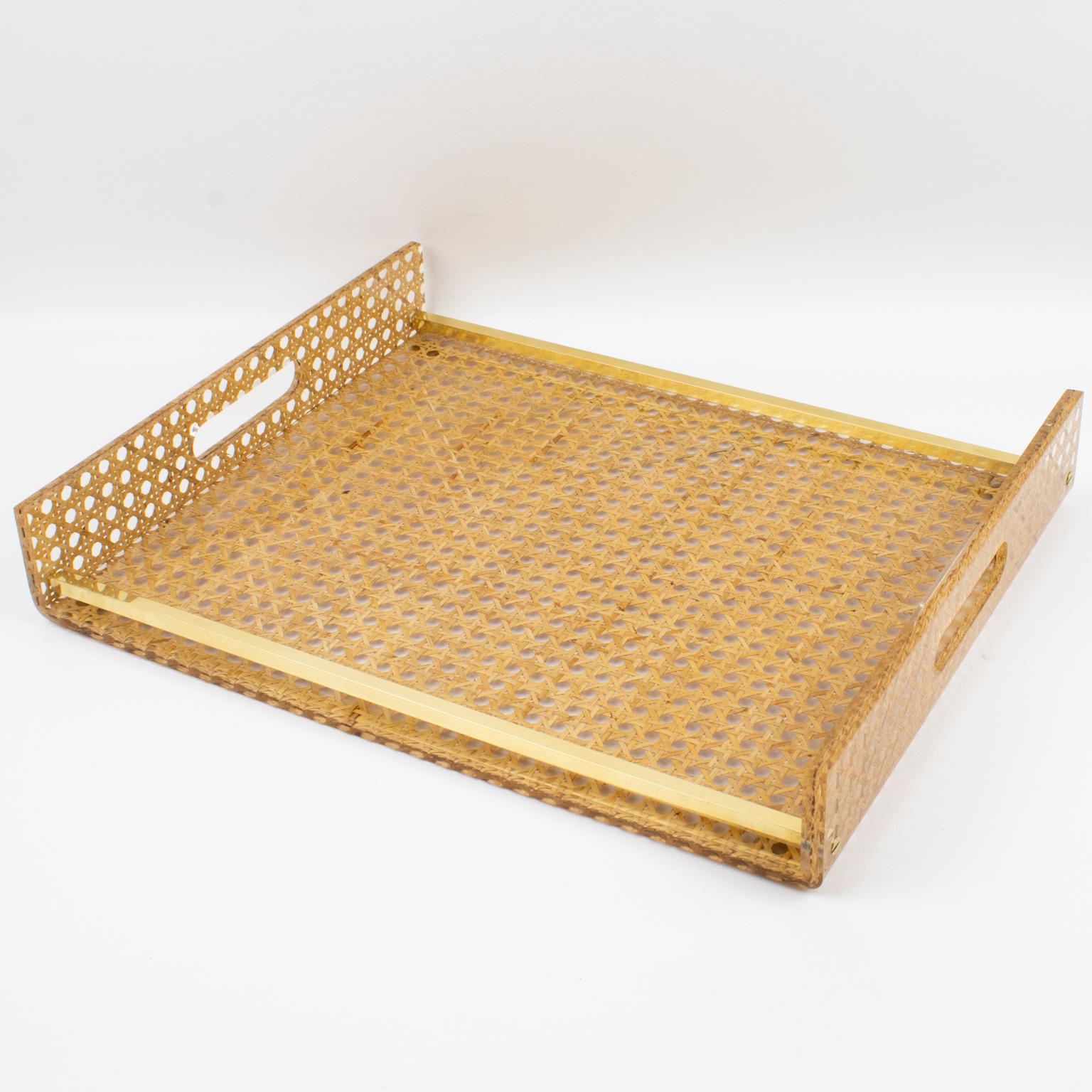 Elegant barware serving tray designed for Christian Dior for his Home Collection, in the 1970s. Rectangular butler shape with gilt brass gallery and real rattan cane-work or wicker embedded in the clear Lucite, or acrylic. Perfect for any modern