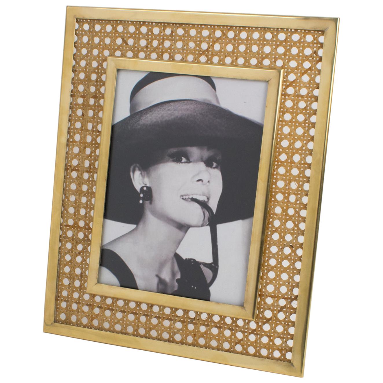 Elegant decorative picture photo frame, designed by Christian Dior for his Home collection in the 1970s. Crystal clear Lucite and rattan or wicker cane work. The rattan is embedded within two sheets of clear Lucite. Gilded brass framing around the