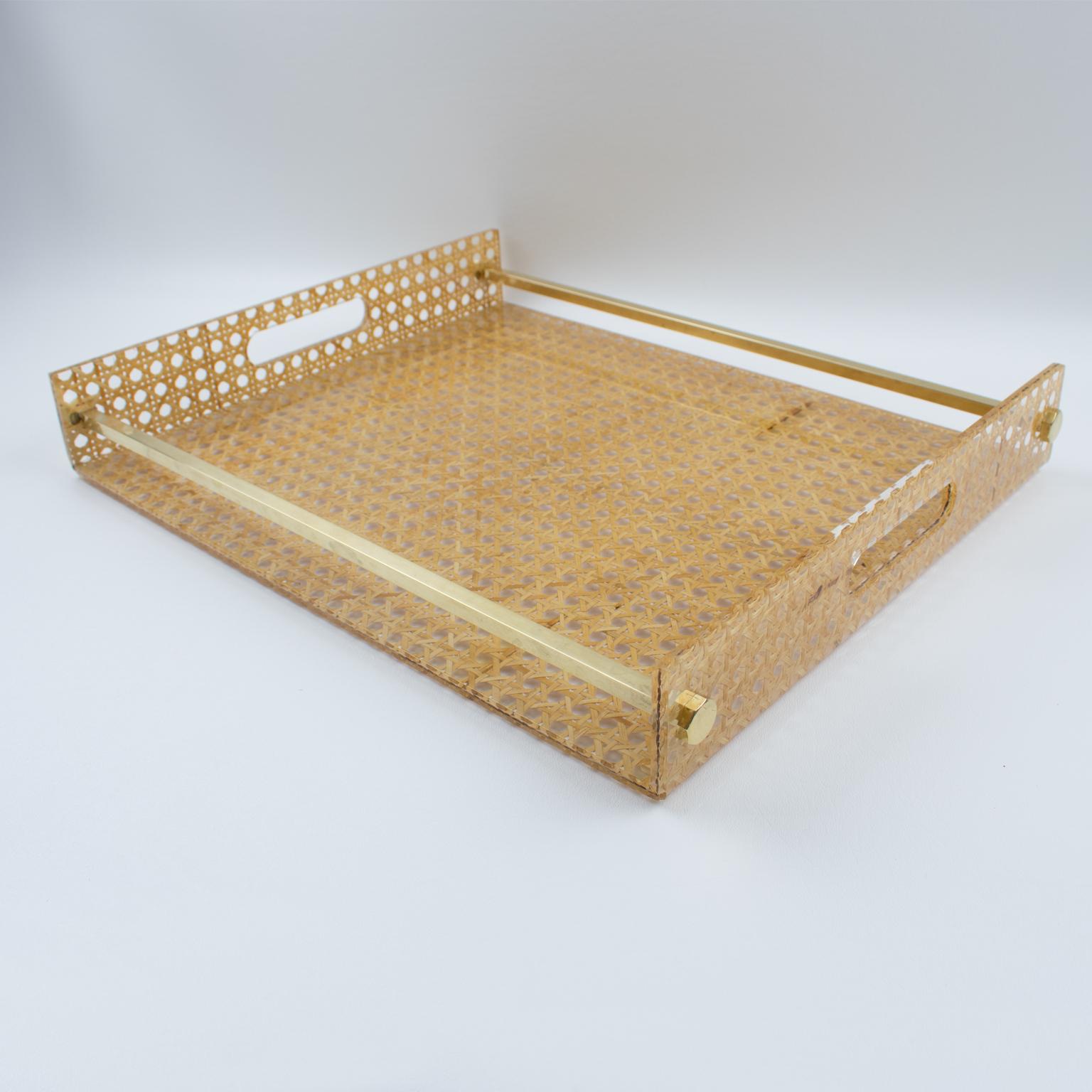 Elegant large barware serving tray designed for Christian Dior home collection, in the 1970s. Rectangular butler shape with gilt brass gallery and real rattan cane-work or wicker embedded in the crystal clear Lucite. Perfect for any modern interior