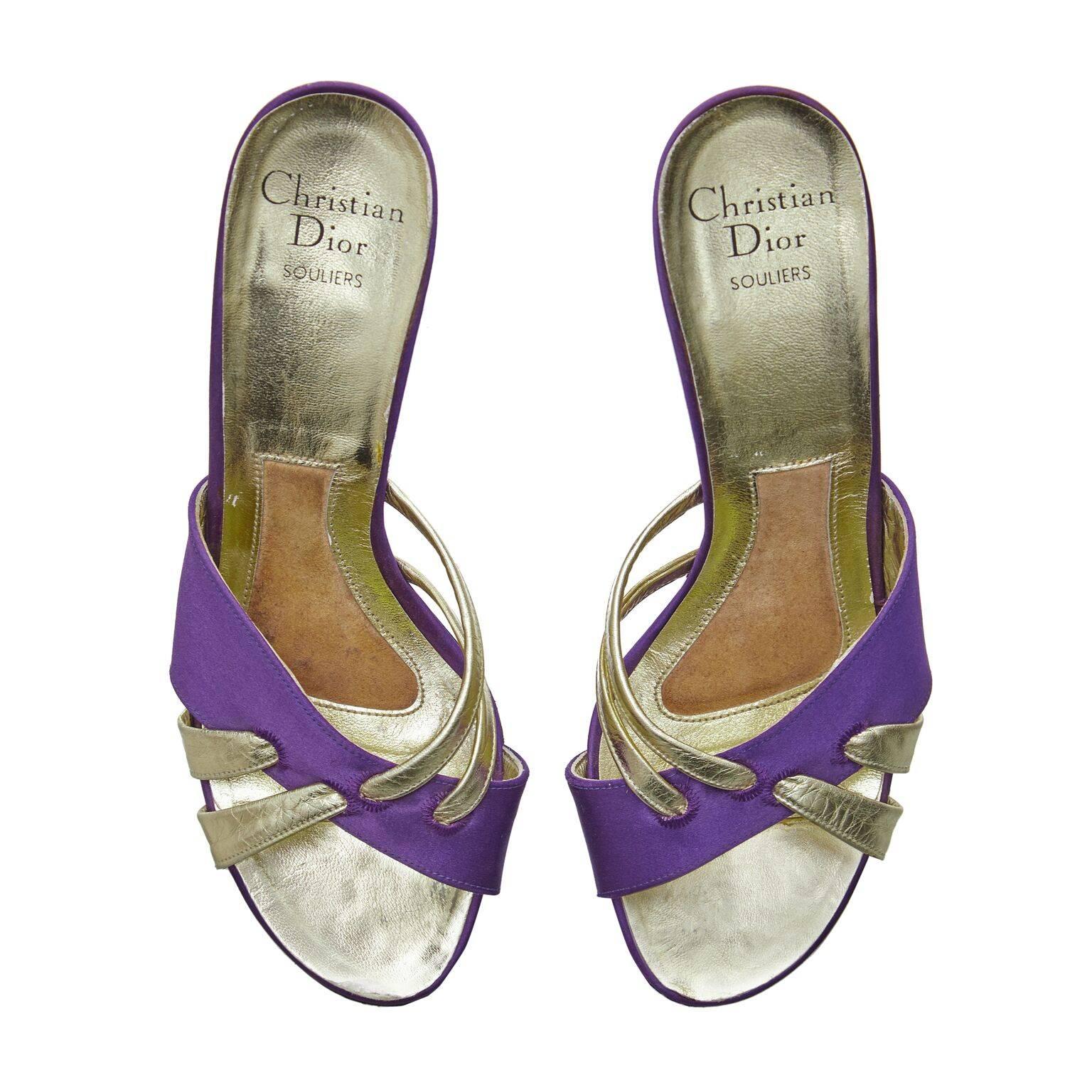 These exquisite 1970s Christian Dior heeled sandals with cross toe detail are beautifully made and in impeccable condition. There is a 3 inch cone heel with open back and toes. Rich purple satin fabric crossing with a gold tone leather double strap