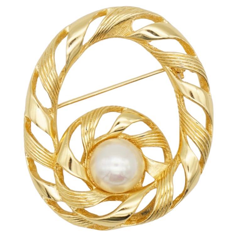 Christian Dior 1970s Vintage Large Oval Swirl Openwork Round Pearl Brooch, Gold Tone

Very excellent condition. 100% genuine.

A unique piece. This is gold plated stylised brooch. Safety-catch pin closure.

Size: 5.0 cm x 4.0 cm.

Weight: 17.0 g.

_