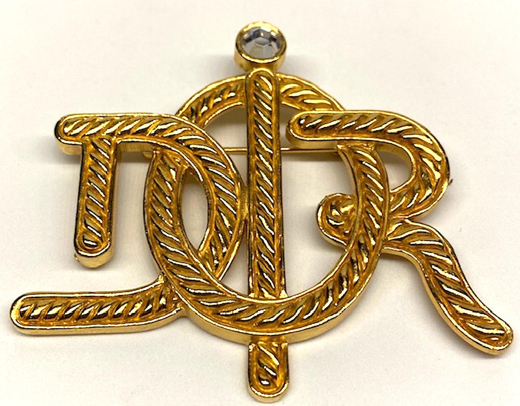 Dior gold tone monogram pin from the mid 1980s. A rope twist with smooth frame work design spells out the Dior name in a monogram or insignia style. The 