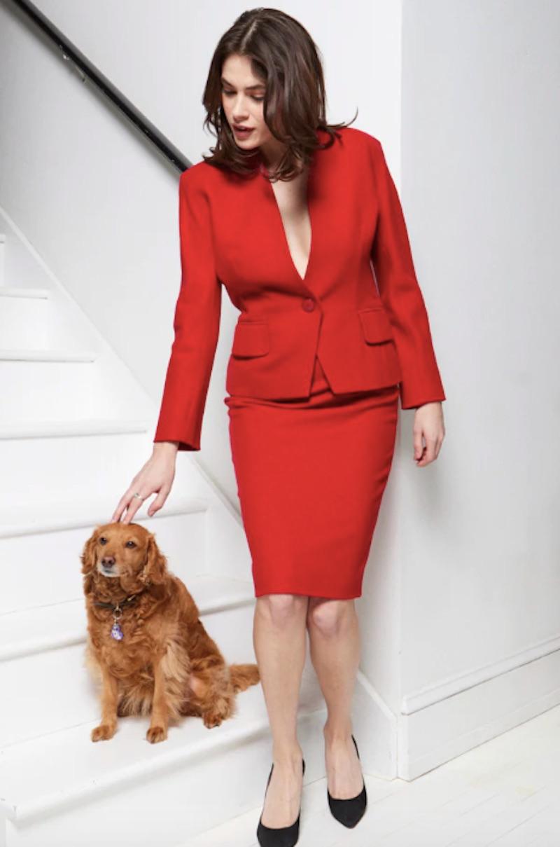 Magnifique tailleur jupe en laine rouge Dior des années 1980. La veste souligne parfaitement la taille, tandis que la jupe est ornée de magnifiques boutons ton sur ton dans le dos. Ce look est un parfait exemple des créations classiques et féminines