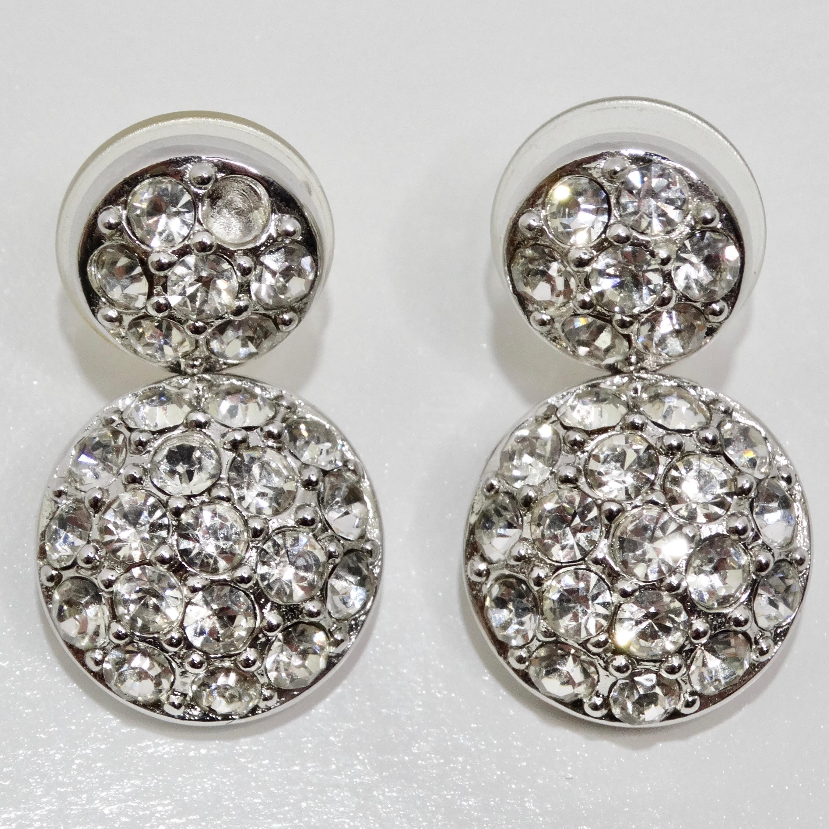 Eleva il tuo stile con gli orecchini con strass Christian Dior 1980, un delizioso paio vintage che aggiunge un perfetto tocco di glamour a qualsiasi look. Questi squisiti orecchini sono caratterizzati da due cerchi placcati in argento che penzolano