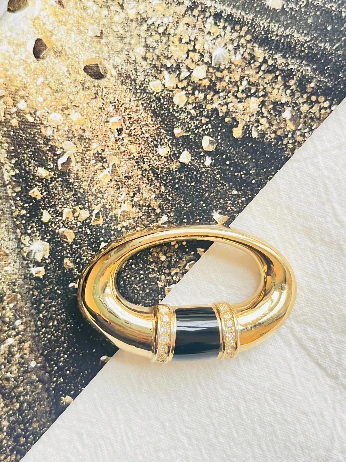 Christian Dior 1980s Vintage Black Enamel Double Crystals Oval Openwork Brooch, Gold Tone

Good condition. Light scratches or colour loss, barely noticeable. Not any stones lost. 100% Genuine. 

This gold plated simple oval brooch features black
