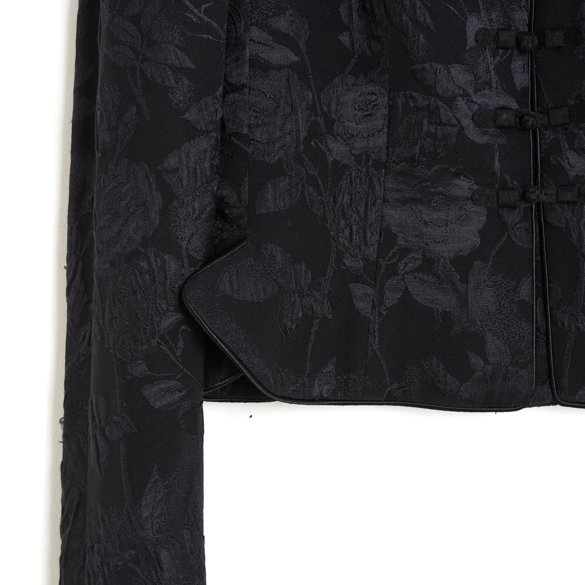 Christian Dior jacket from the SS1999 collection by John Galliano in black silk damask with floral pattern, Mao stand-up collar closed over the entire height by a series of Asian-inspired braid buttons, 2 notches on each side of the jacket, raglan