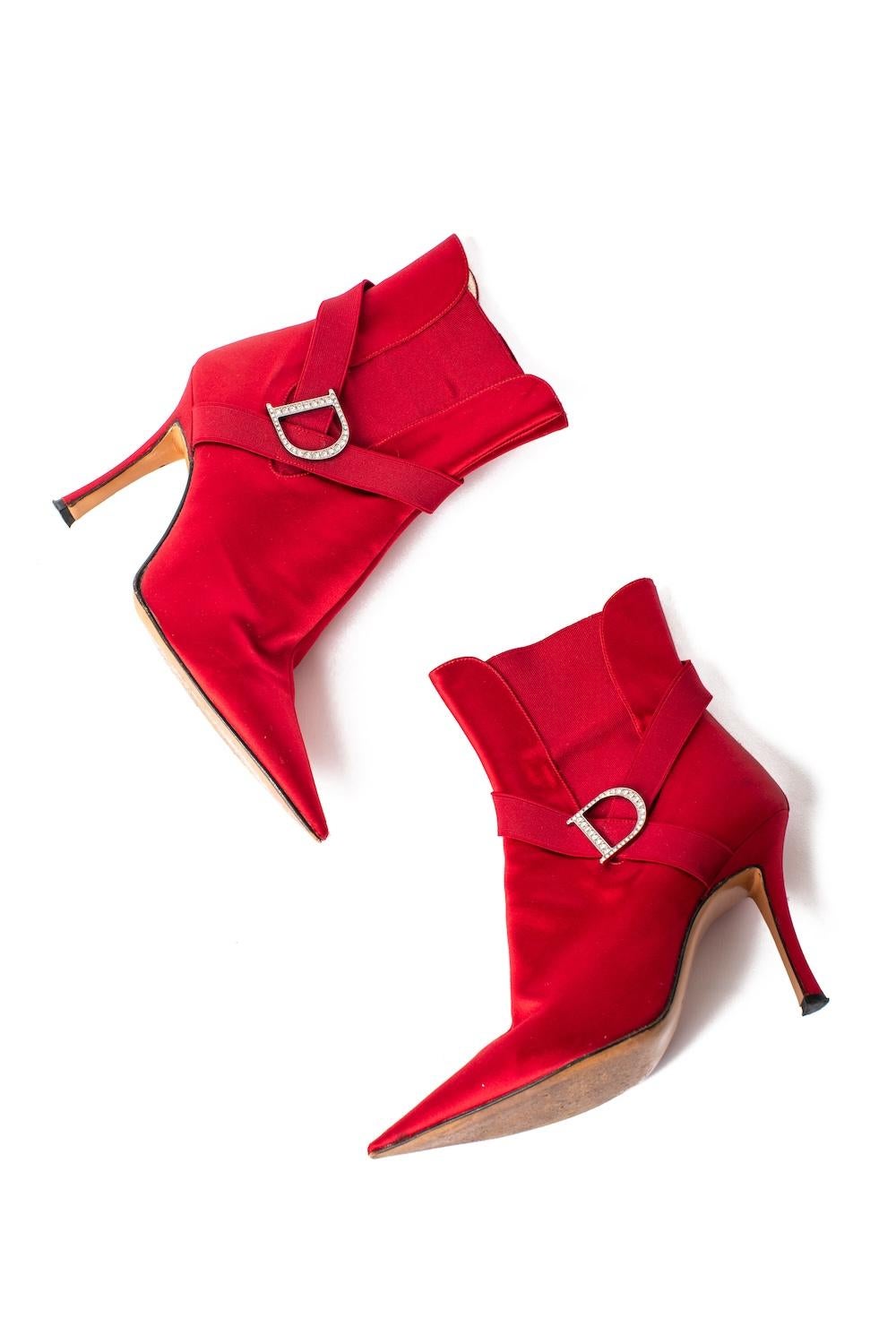 Dating to the early 2000's, these Christian Dior ankle boots are made from glossy red satin with elastic accents and a crystal D logo on the side of the foot, and also feature a pointed toe & four inch stiletto heel. Made in Italy, these were