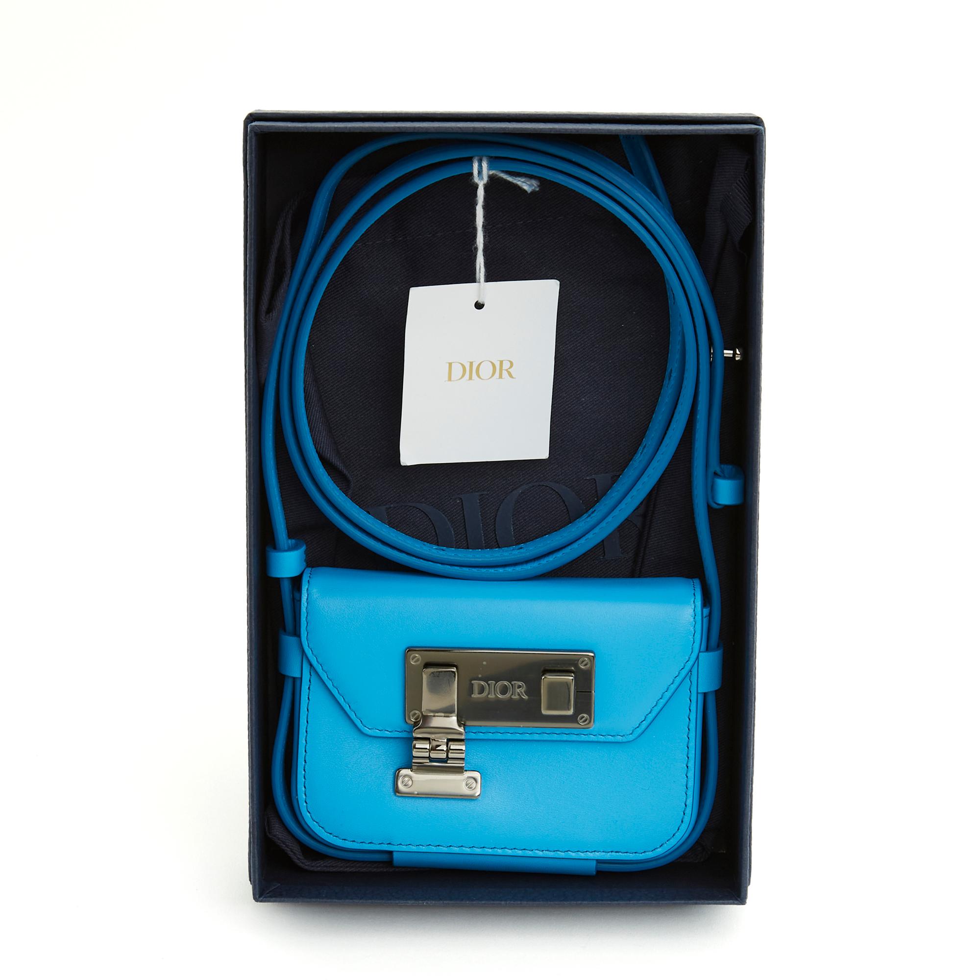 Nano Christian Dior pouch in royal blue leather, clasp in slightly dark silver metal (ruthenium) with the Dior logo, interior in black canvas with a patch pocket for a card, long adjustable shoulder strap for cross-body wear. Width 11.5 cm x height
