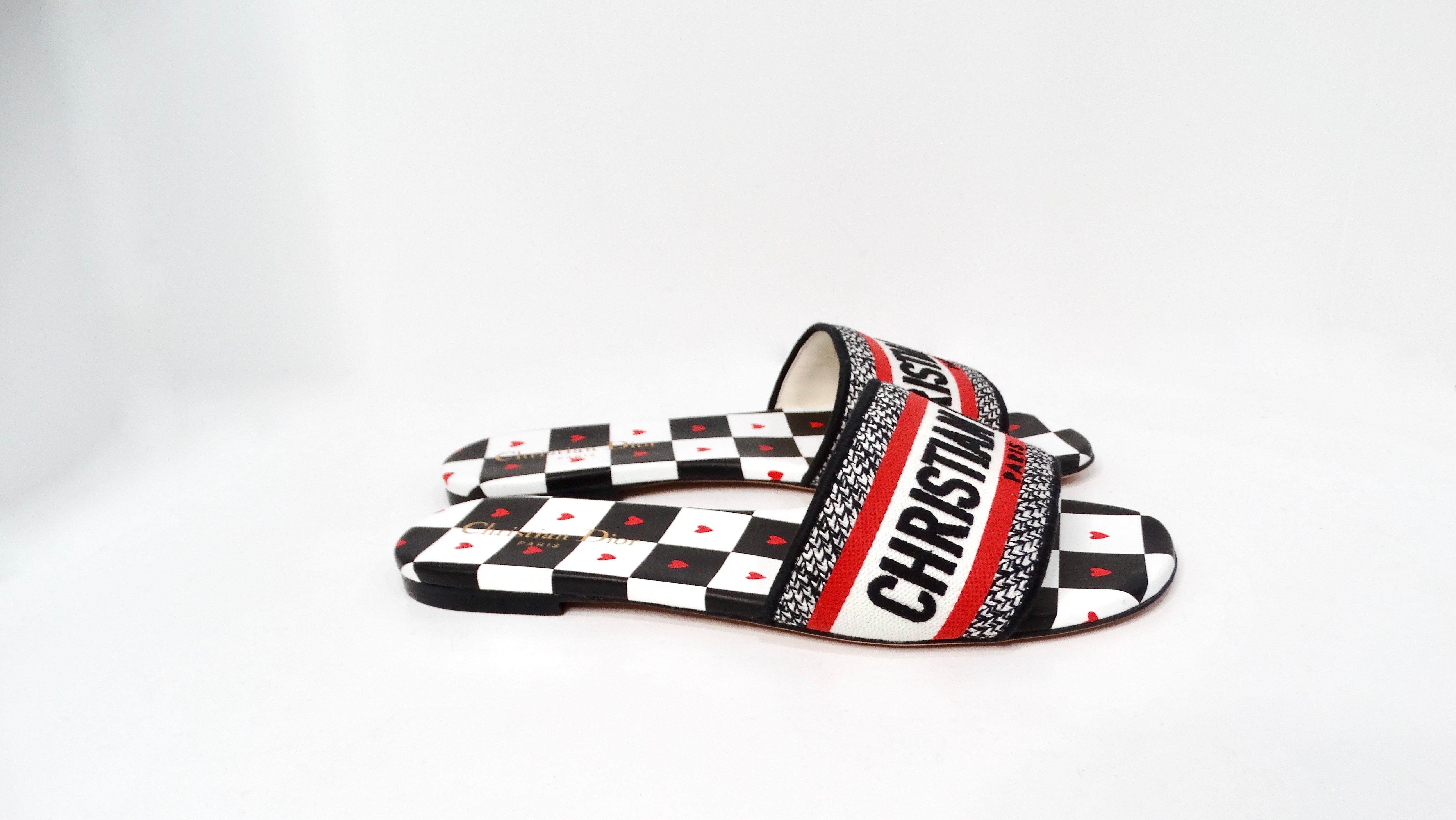 Las Chanclas Christian Dior 2021 Dway Dioramour son una asombrosa fusión de lujo y capricho, que encarna el espíritu de la elegancia moderna. Confeccionadas con una suela de cuero blanco y negro a cuadros, estas chanclas están adornadas con pequeños