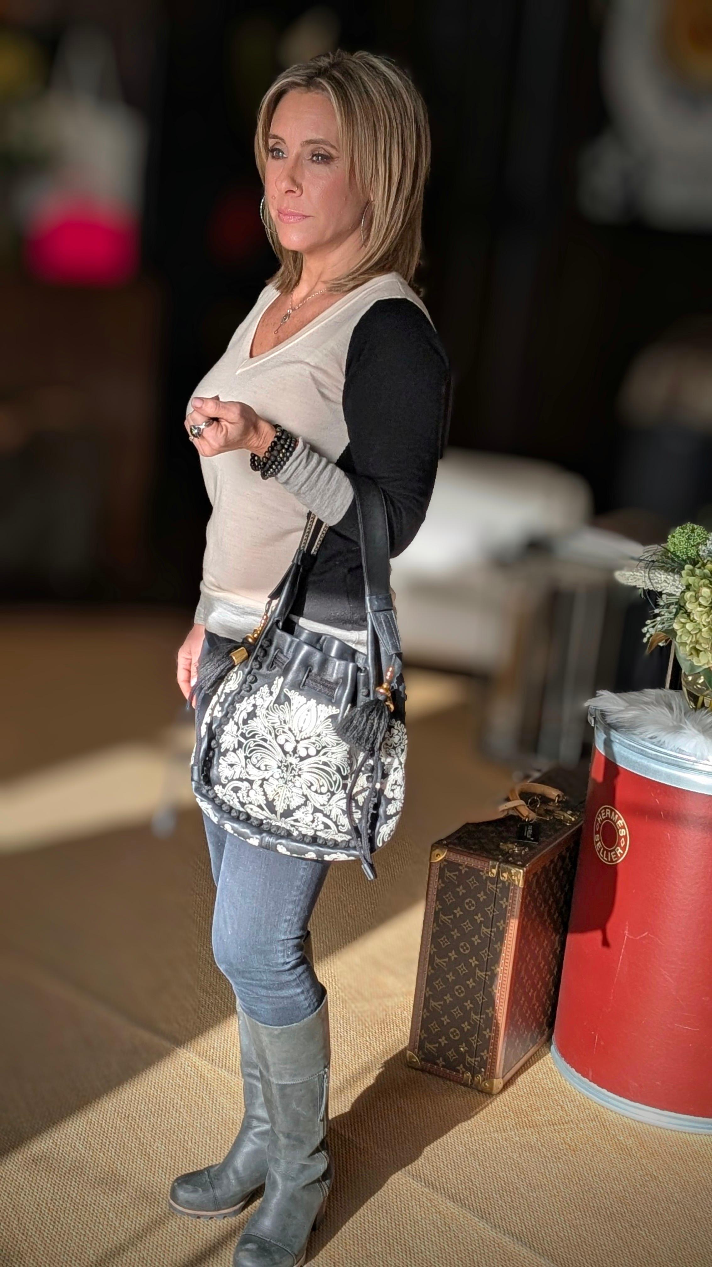 Indulge in luxury and sophistication with the Christian Dior Ornamental Cornely-Effect Hobo Bag. Crafted in Italy from embroidered leather, this bag features a unique design and 'Christian Dior' lettering on the shoulder strap. The spacious interior
