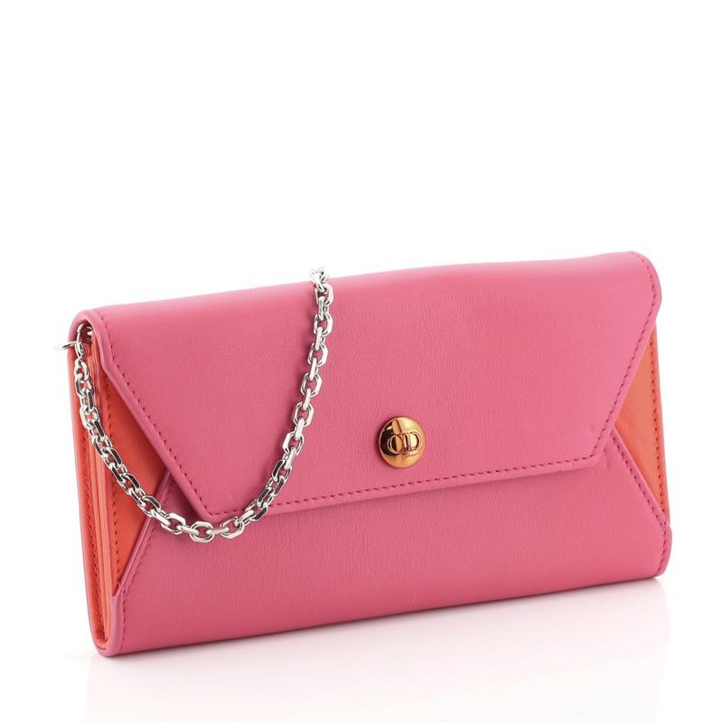 This Christian Dior Addict Rendez Vous Wallet on Chain Leather, crafted in purple leather, features a chain-link strap, metal CD snap and silver-tone hardware. Its press-stud closure opens to an orange leather interior with multiple card slots and