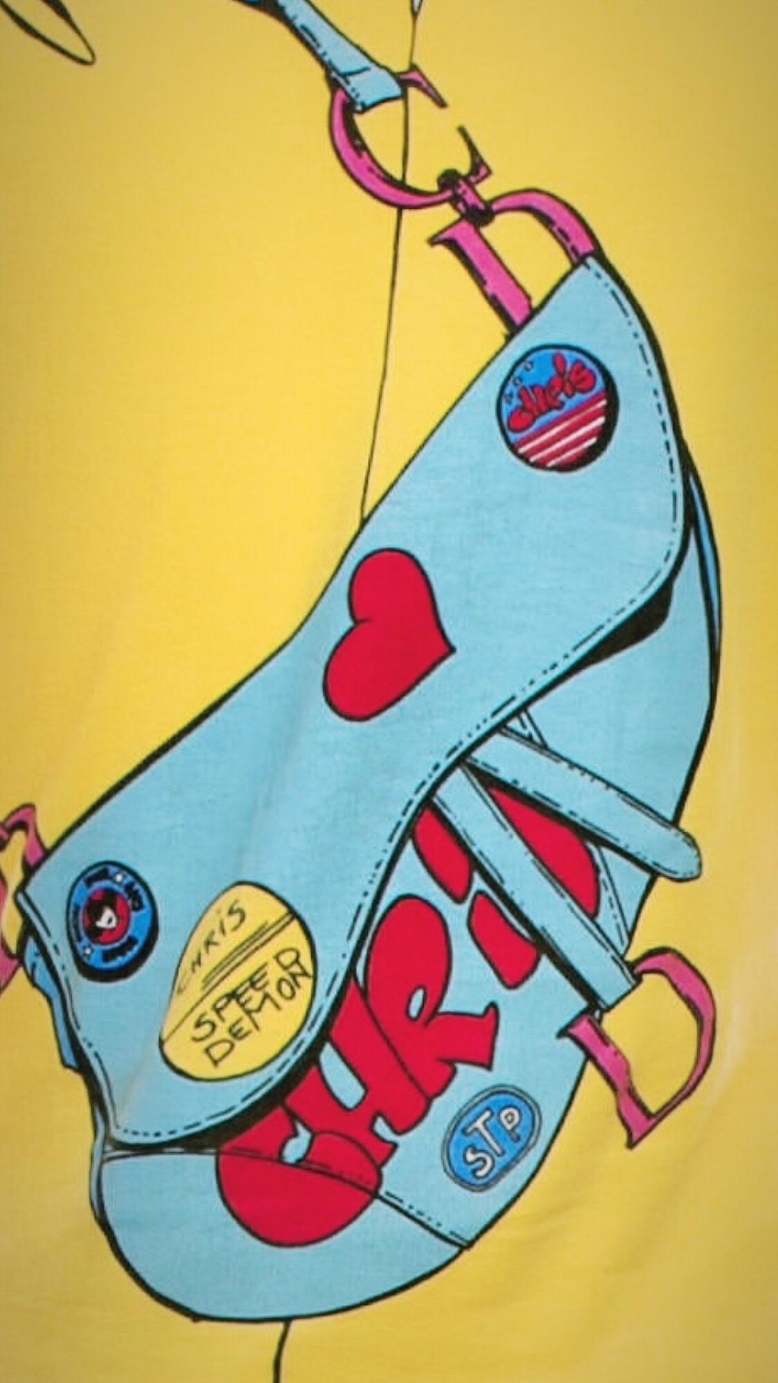 ¡Para la amante definitiva de Dior! Diseñada por Galliano hacia 2002, esta camisa de manga larga de color amarillo brillante presenta un motivo impreso de estilo de dibujos animados de una camisa abotonada con botones rosas con el logotipo, gafas de