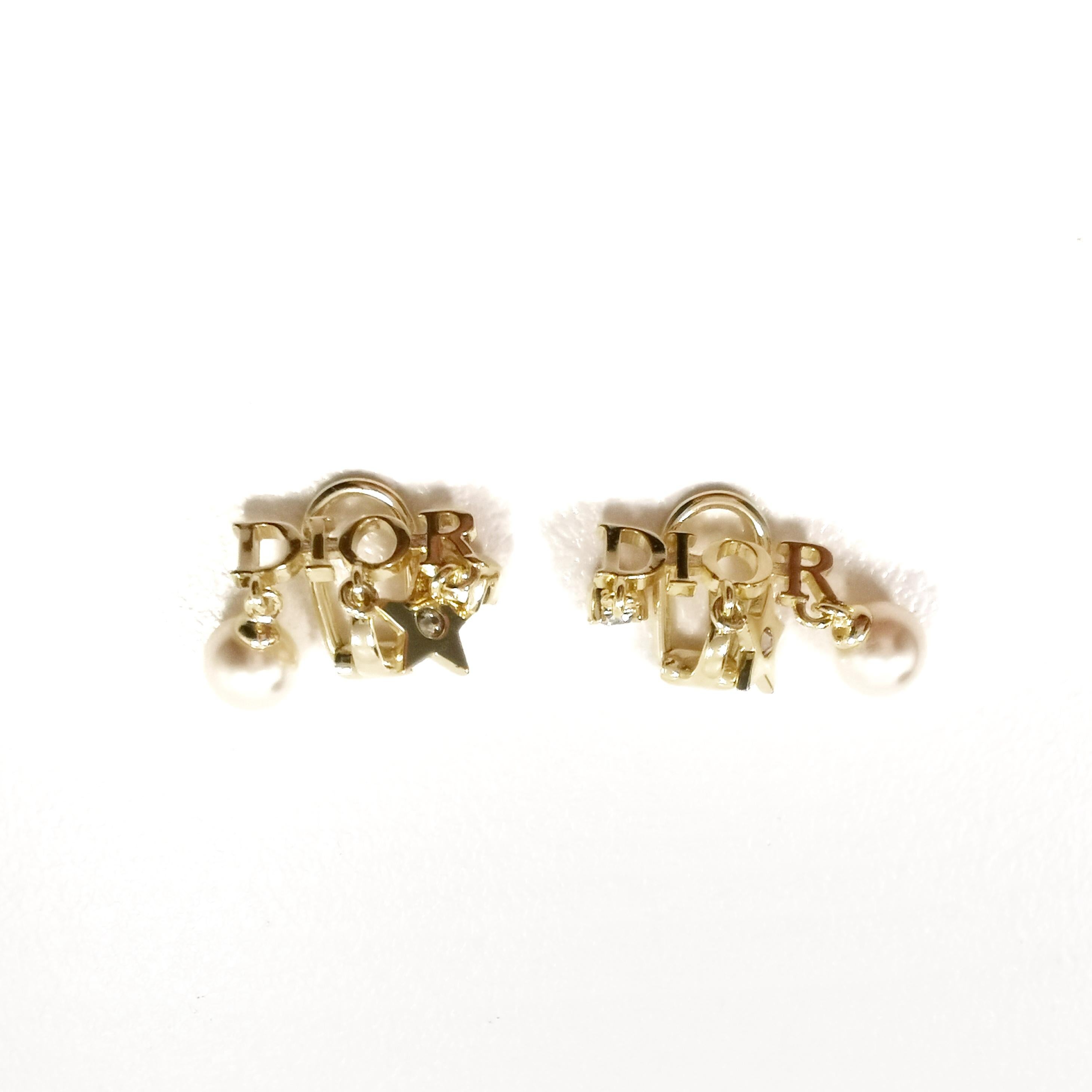 Introducing the Christian Dior Alphabet with Star and Drop Pearl Small Clip-On Earrings in Light Gold – a stunning fusion of elegance and whimsy that embodies the essence of Dior's legendary craftsmanship and creativity. These exquisite clip-on