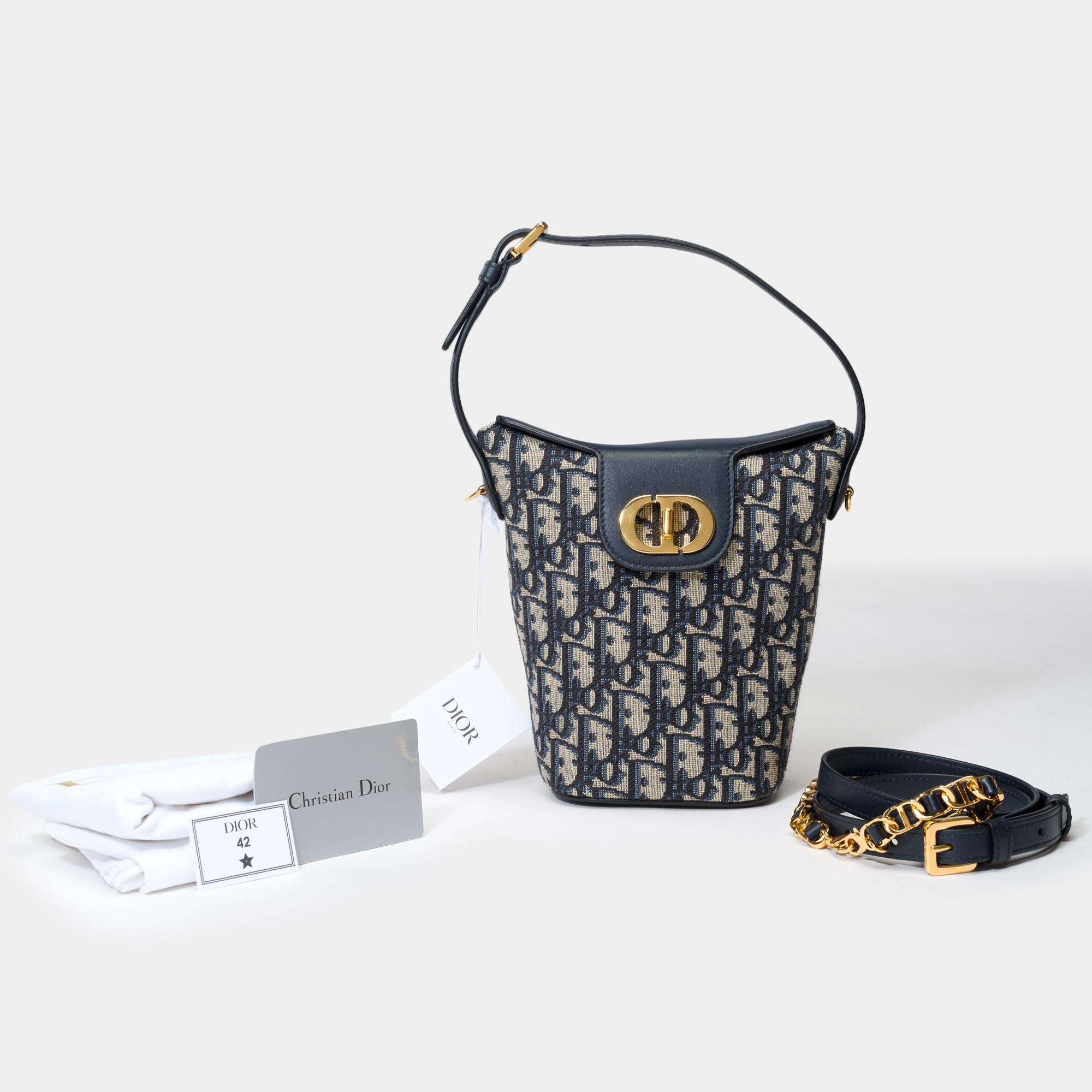 Die Dior Amber 30 Montaigne Mini Bucket Bag ist eine elegante Kreation mit zeitlosem Look und neu für die Cruise 2024 Saison. Sie ist aus blauem Dior Oblique Jacquard-Canvas gefertigt und wird durch eine elegante Klappe aus Kalbsleder Ton in Ton