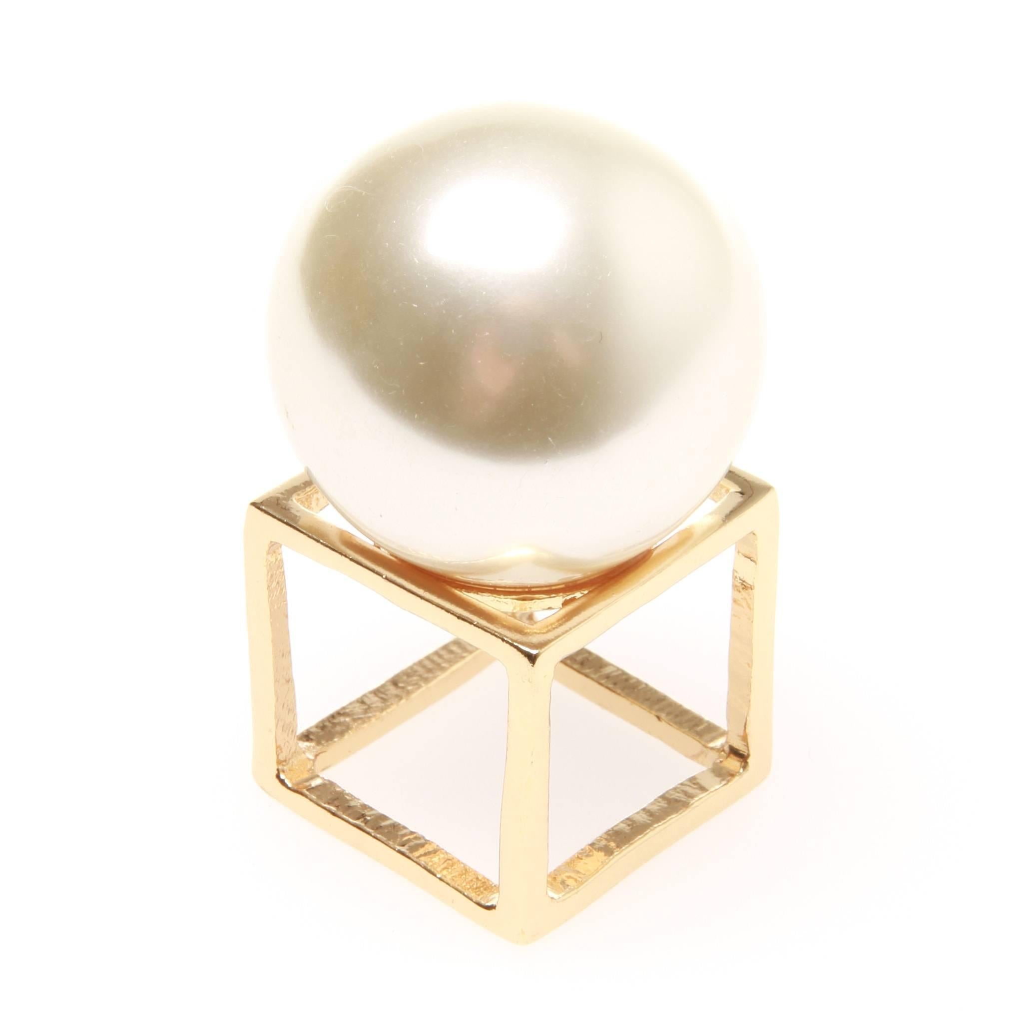 Christian Dior couture runway ring featuring a gold-tone cube as ring band with an oversized faux pearl sitting atop. 

Size approx US 8.75
