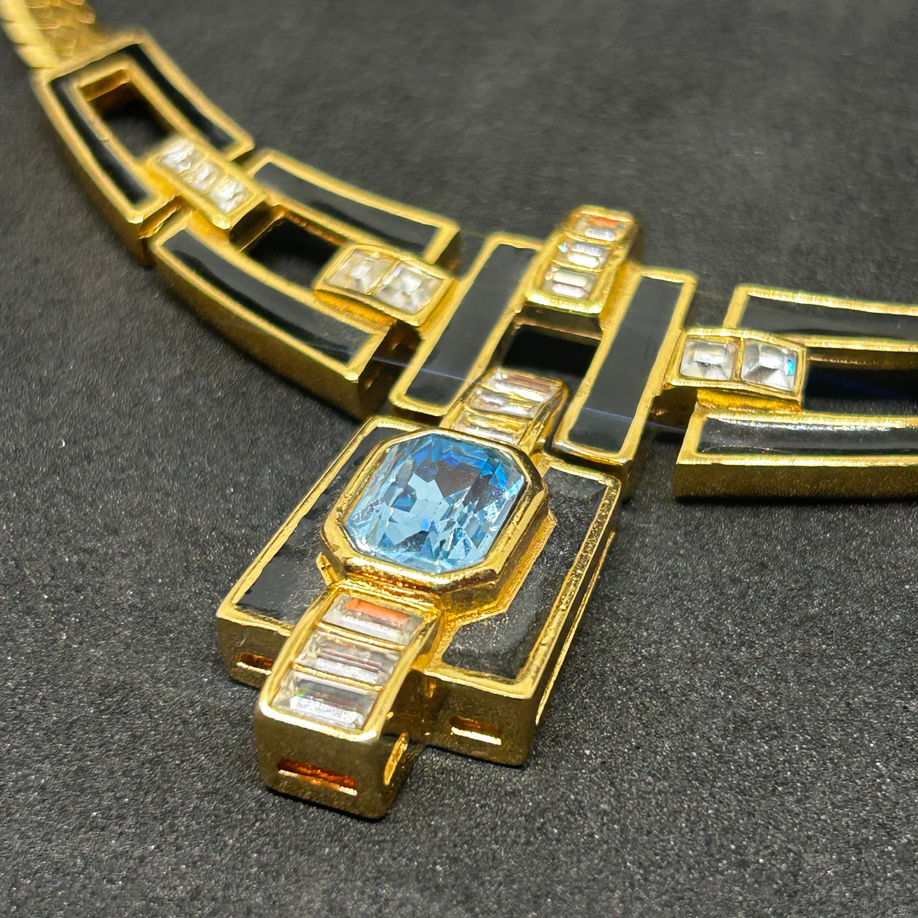 This necklace made by Christian Dior is a stunning example of bold design and sophisticated craftsmanship. The necklace's structure incorporates a striking geometric pattern at its center, with angular black and metallic rectangles interlocked to