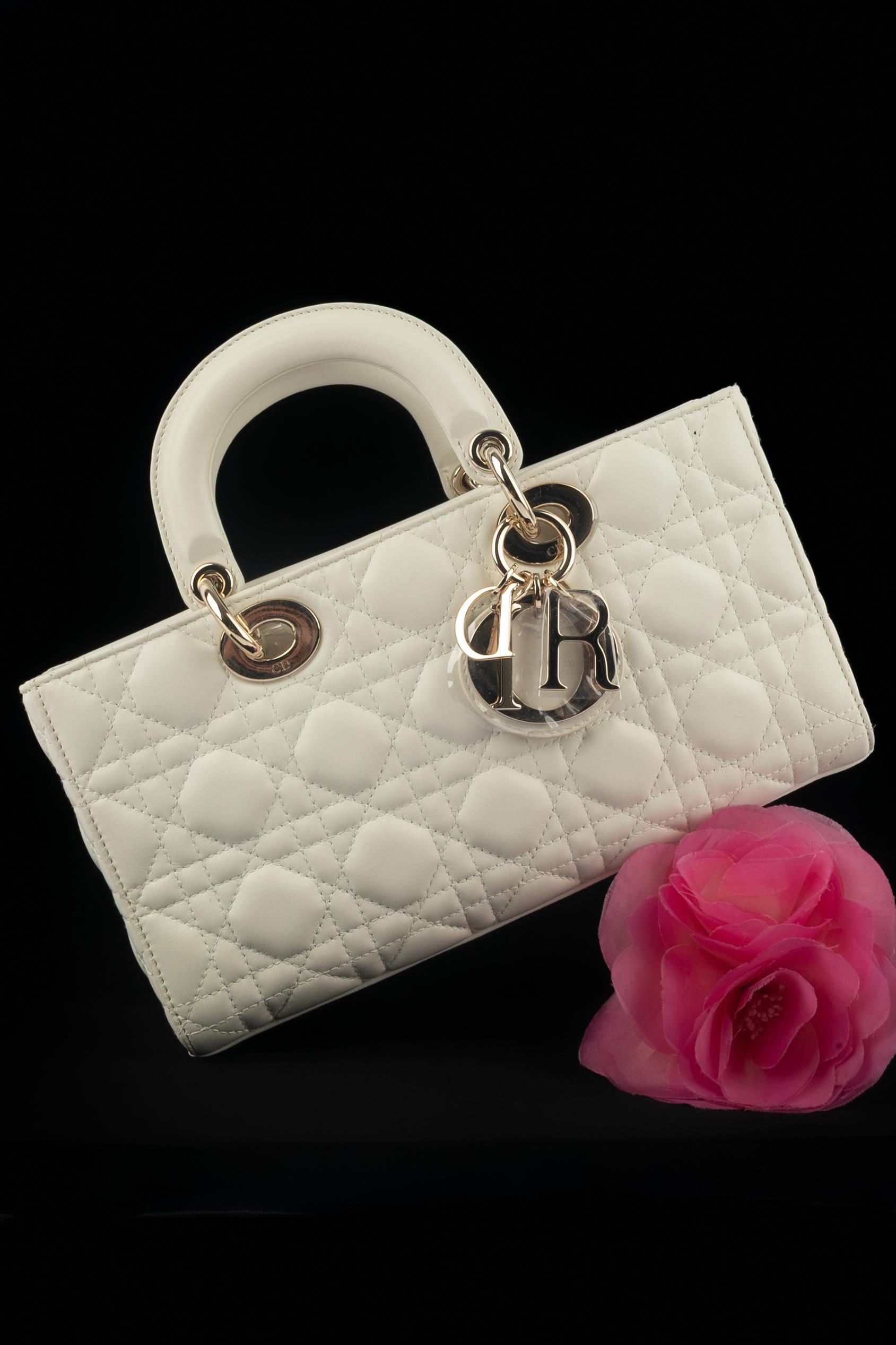 DIOR - (Fabriqué en Italie) Sac Lady D-Joy en cuir d'agneau blanc cassé avec des surpiqûres de cannage. Double poignée et sangle amovible. Éléments métalliques dorés. Pièce avec un numéro de série et une carte d'authenticité. Une Collectional 2022
