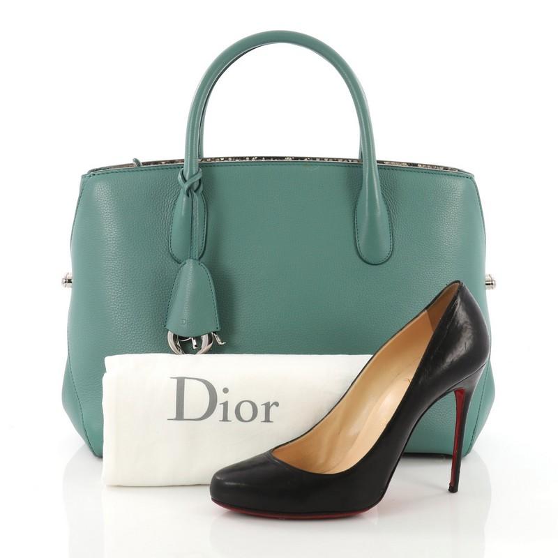 This Christian Dior Bar Bag Leather Medium, crafted in green leather, features dual rolled handles, side push pin closures, and silver-tone hardware. Its zip closure opens to a green leather interior with snap and slip pockets. **Note: Shoe
