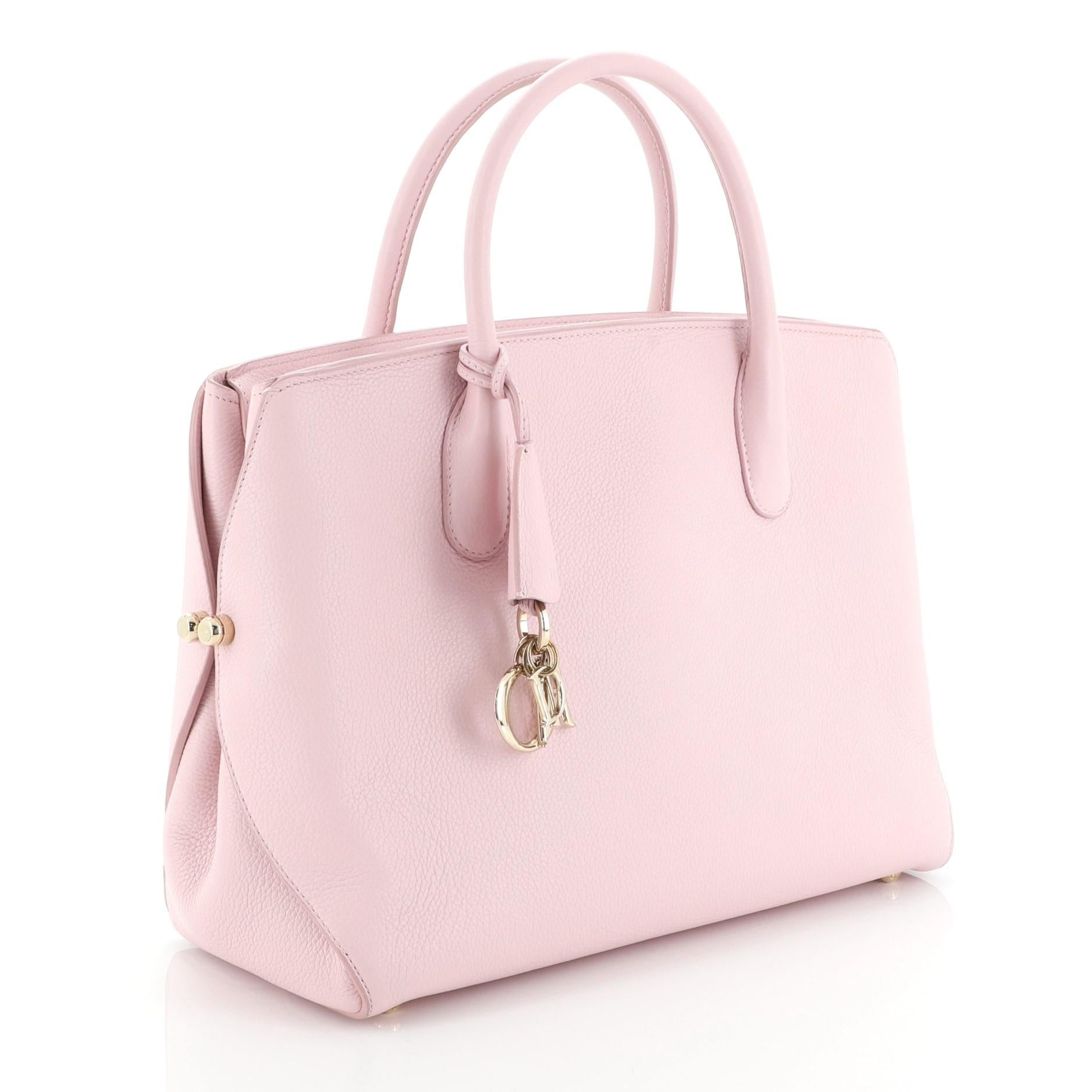 This Christian Dior Bar Bag Leather Medium, crafted from pink leather, features dual rolled handles, Dior charms and gold-tone hardware. Its zip closure opens to a pink leather interior. 

Estimated Retail Price: $4,800
Condition: Damaged. Repainted