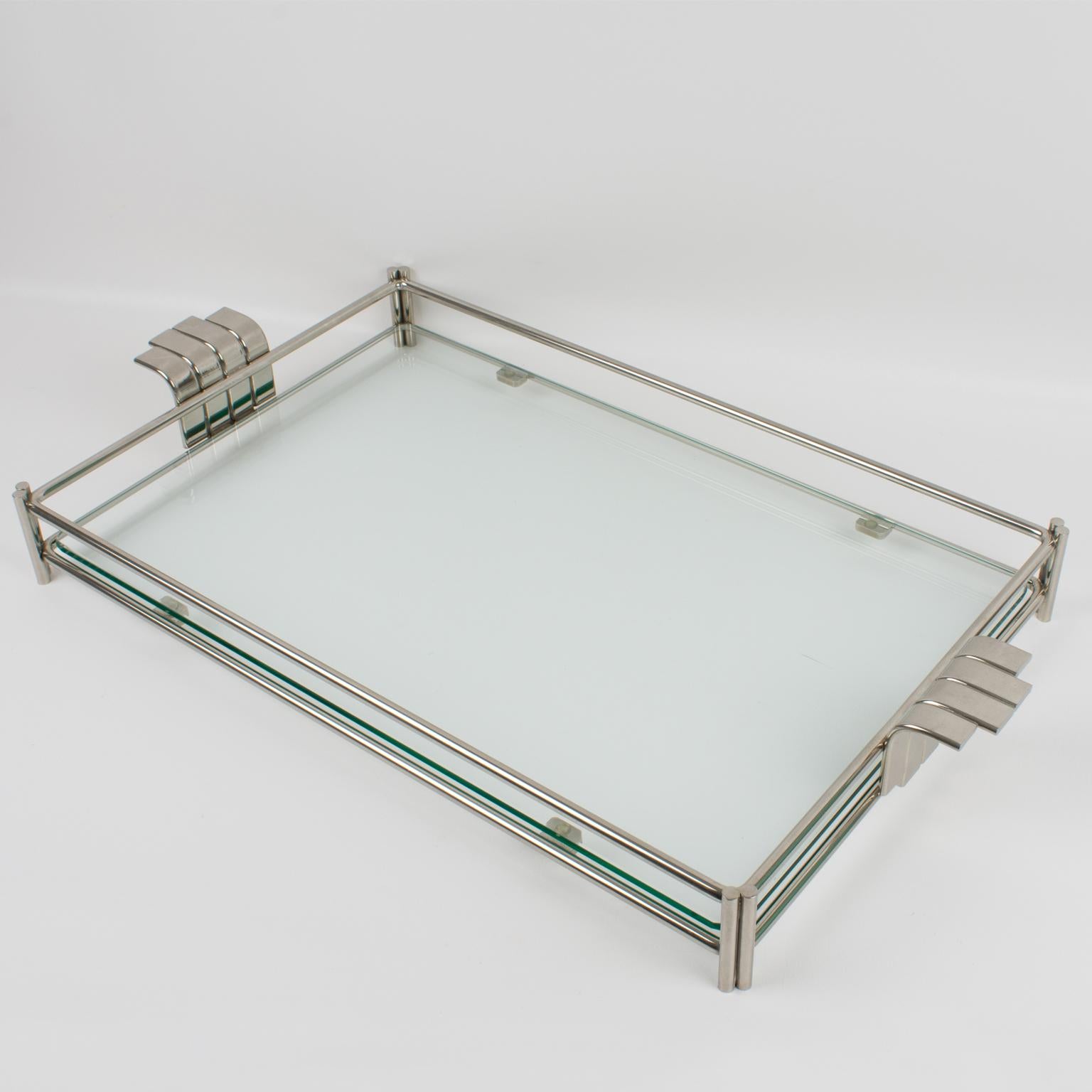 This sophisticated modernist barware serving tray platter was designed for Christian Dior Home Collection in the 1980s. The large rectangular butler shape is built with silvered metal framing and a thick glass slab insert. The tray is embellished