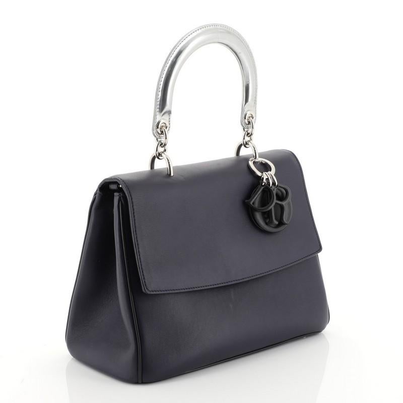This Christian Dior Be Dior Bag Smooth Leather Small, crafted from blue smooth leather, features leather handle with Dior charms, side snap buttons, exterior back pocket, protective base studs and silver-tone hardware. Its flap opens to a blue
