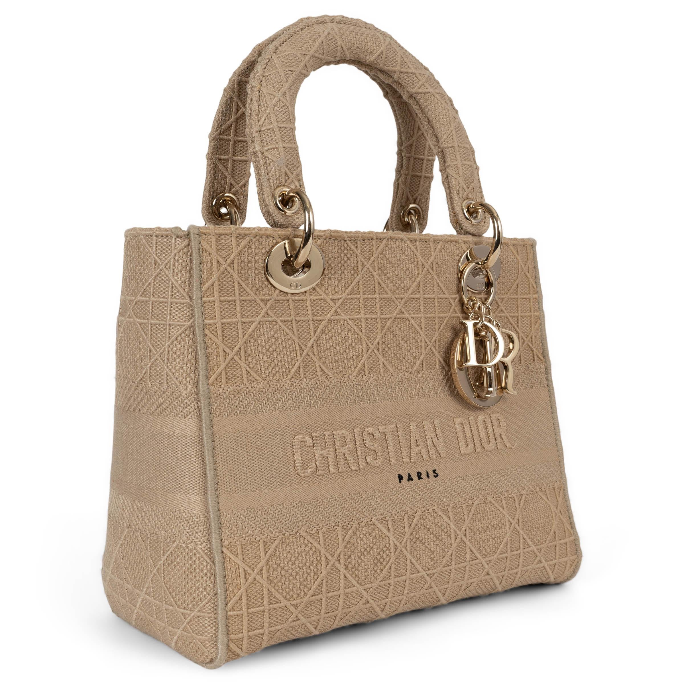 Este bolso tote 100% auténtico Christian Dior Medium Lady D-Lite de lona bordada cannage beige es una sofisticada mezcla de elegancia y versatilidad. Con herrajes en tono dorado claro, se abre con una solapa y cierre magnético a presión, ofreciendo