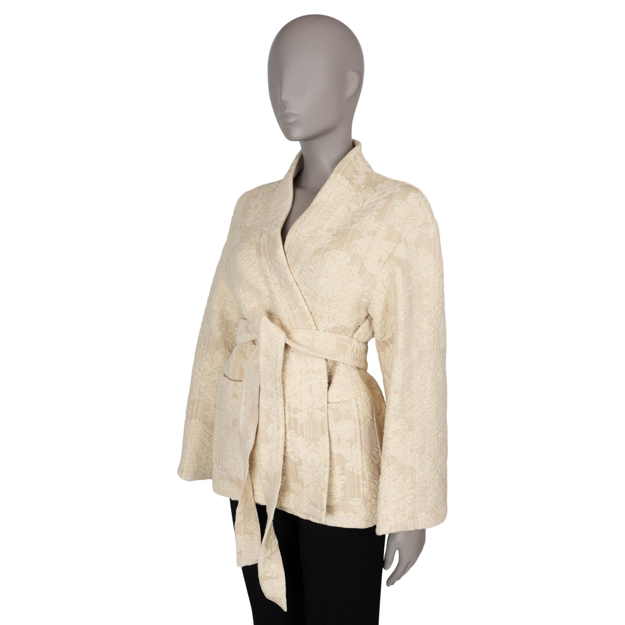 This 100% authentic Christian Dior kimono jacket in beige chunky damask offers a luxurious take on relaxed elegance. Crafted from a blend of cotton (70%) and viscose (30%), it showcases a beautiful floral design that adds texture and depth. With an
