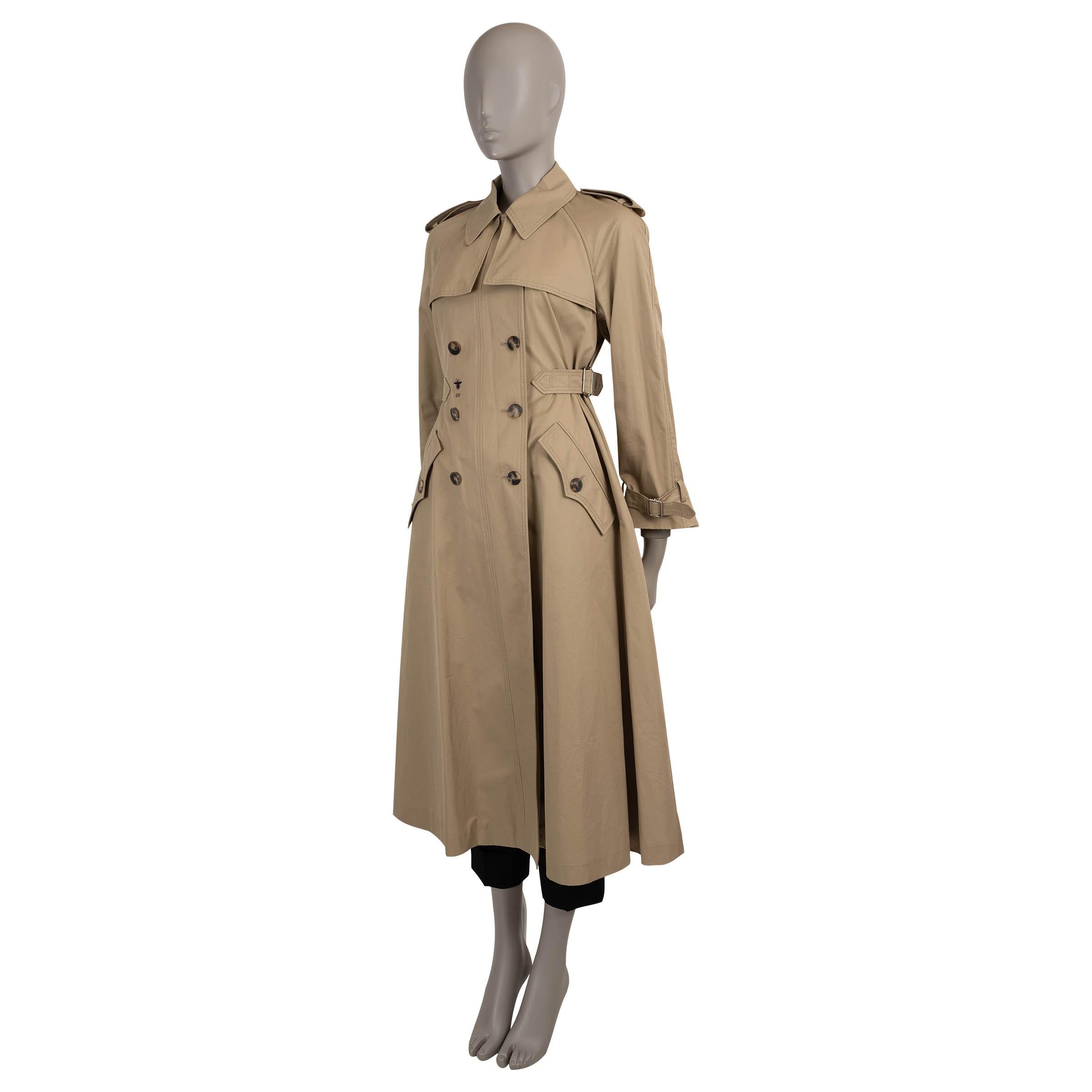 Questo trench di Christian Dior, autentico al 100%, è realizzato in gabardine di cotone beige (100%) e sfoggia una sartoria senza tempo con un tocco moderno di Dior. Presenta revers dentellati, spalline, cinghie regolabili in vita e sui polsini e