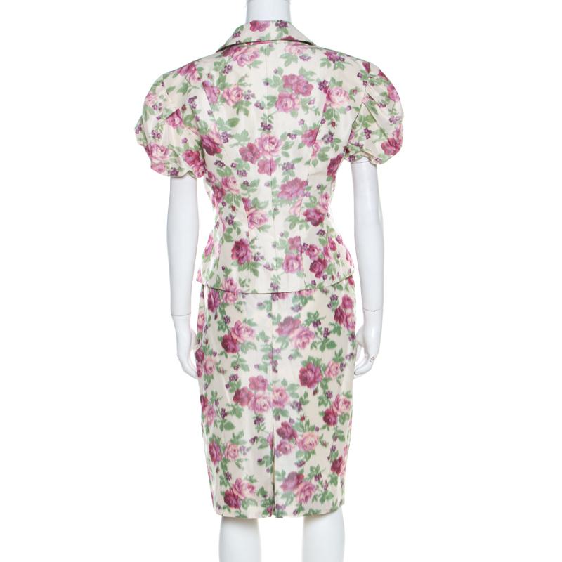 Christian Dior expresses its elegant aesthetics quite magnificently with this skirt suit. Ideal for power dressing, this suit is tailored finely from silk. The subtle floral prints on the beige background, puffed short sleeves and chic silhouette