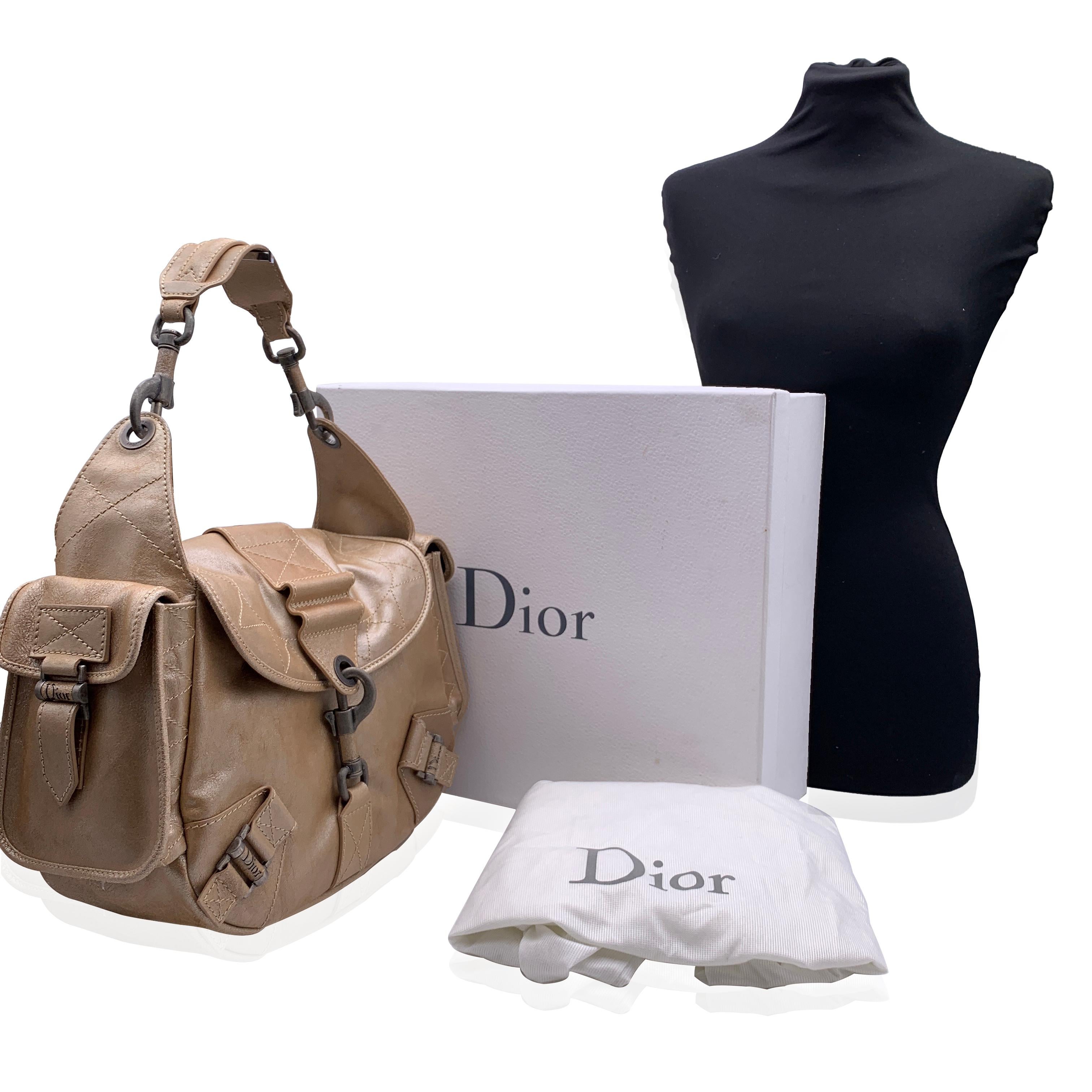 CHRISTIAN DIOR 'Rebelle' shoulder bag in leather from the 2006 collection. Beige color. Silver metal hardware. Flap with carabiner closure on the front. Flap pockets on the sides. Brown suede lining. 1 side zip pocket and 2 side open pockets inside.