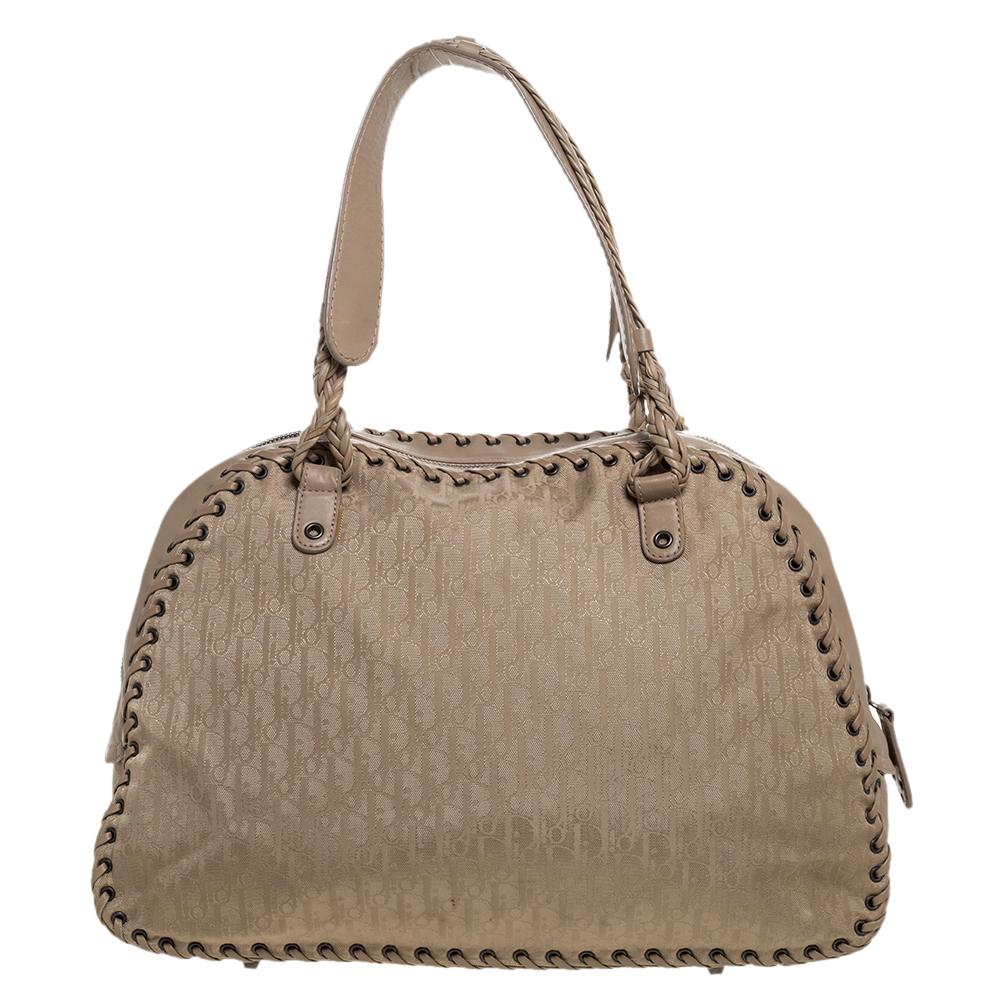 Crafted with Oblique canvas and lined with fabric, you will find this stunning Dior bag an ideal companion for all your needs. It features whipstitch details on the exterior, dual handles and a studded heart charm on the front. The interior is