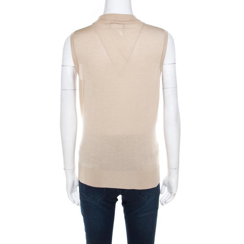 How stylish is this sleeveless top from Christian Dior! The beige creation is made of a silk blend and features a flattering silhouette. It flaunts a high-collared neckline that is embellished with beads and promises to lend you an amazing fit.