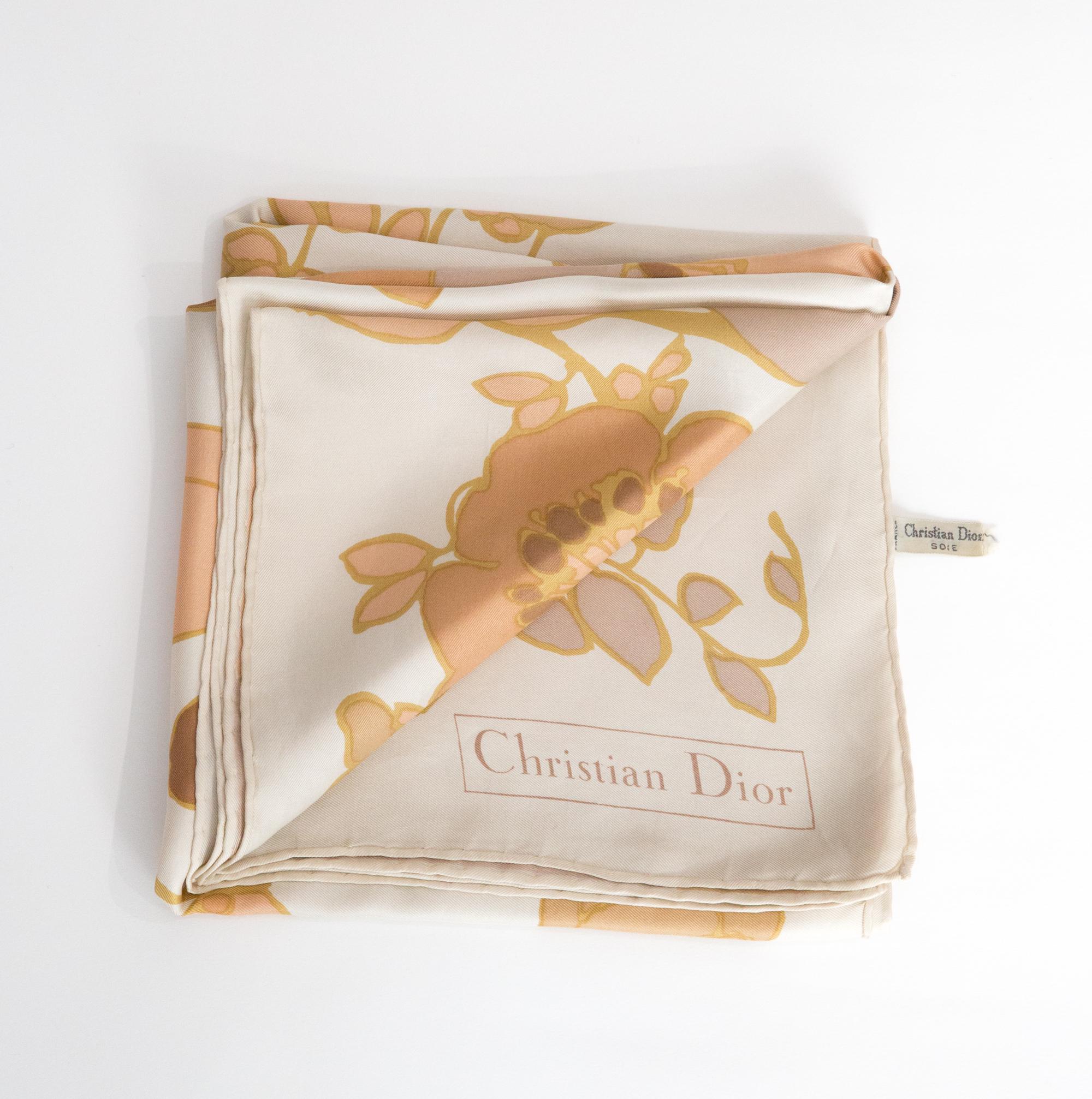 Christian Dior Beige Silk Scarf featuring a pastel flower print, and a top logo signature. 
100% silk. 
Circa 1970s
In good vintage condition. Made in France.
29.9in. (76cm) X 29.9in. (76cm)
We guarantee you will receive this  iconic item as