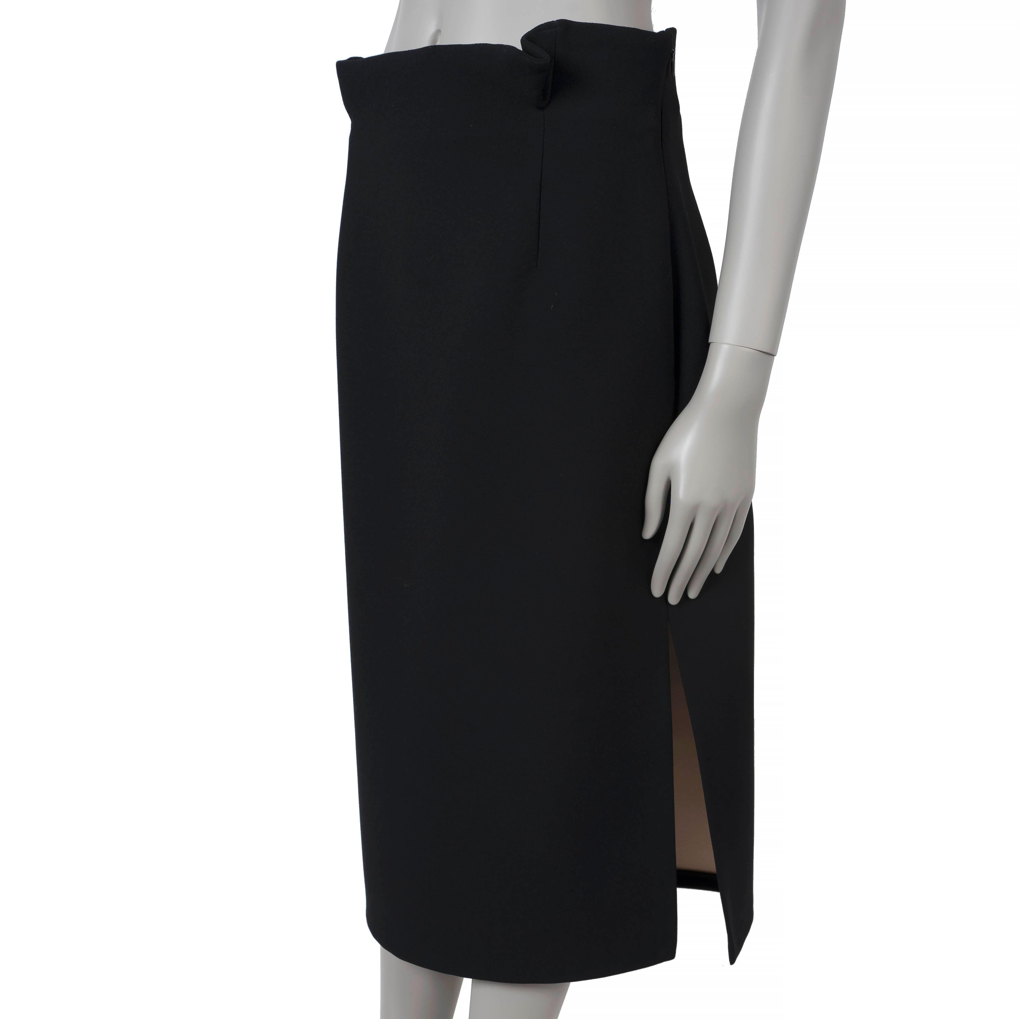 Esta falda lápiz 100% auténtica Christian Dior está confeccionada en acetato negro (60%) y poliéster (40%). Presenta una silueta clásica de talle alto con una longitud midi y una abertura lateral para un aspecto elegante y estilizado. La falda se