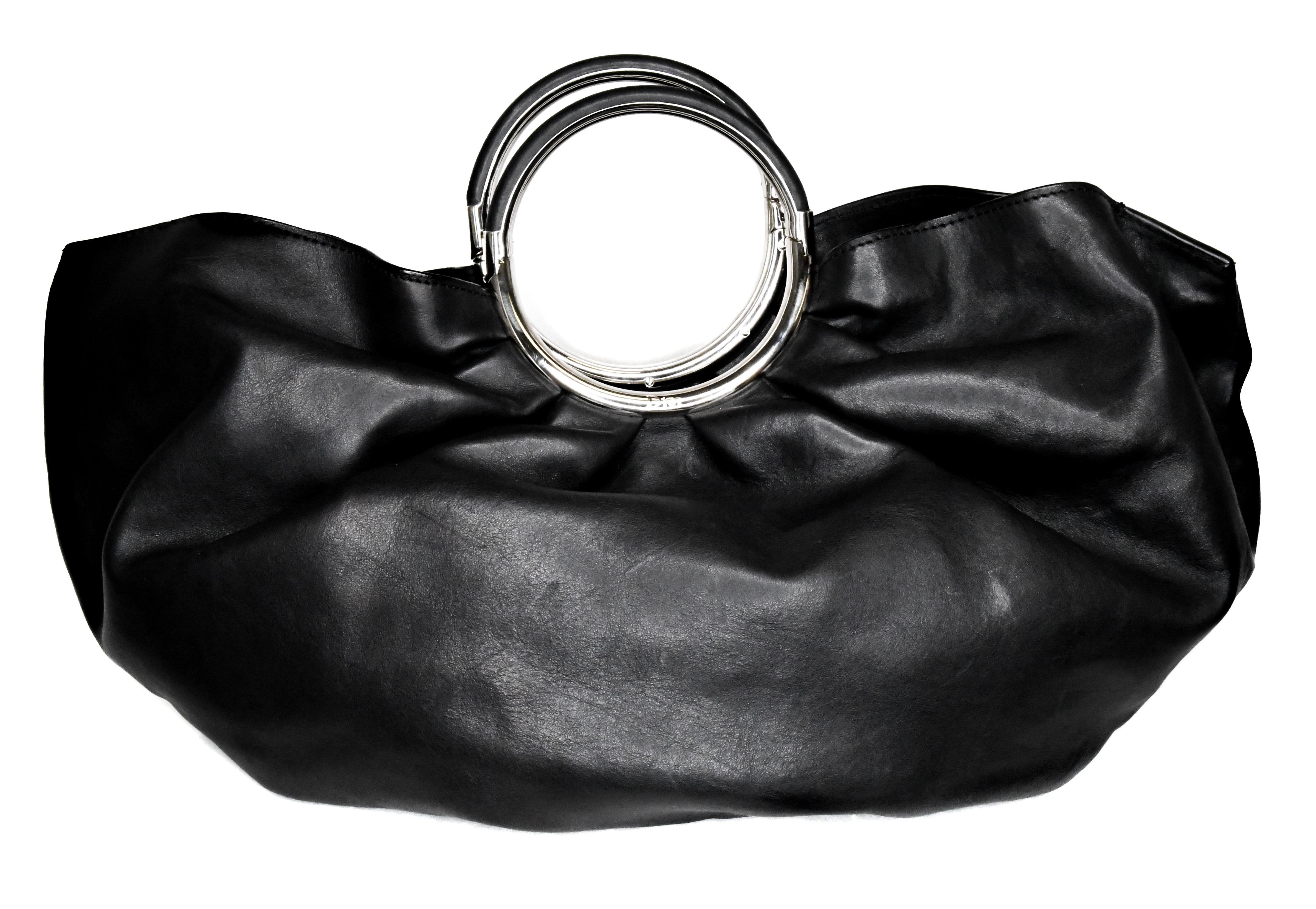 Christian Dior Babe Bag in black is a must for any collector of Dior designed by John Galliano.  Features ultra-luxurious black leather, gathered silhouette, and silver tone metal and leather round handles.  Handles are hinged for comfortable