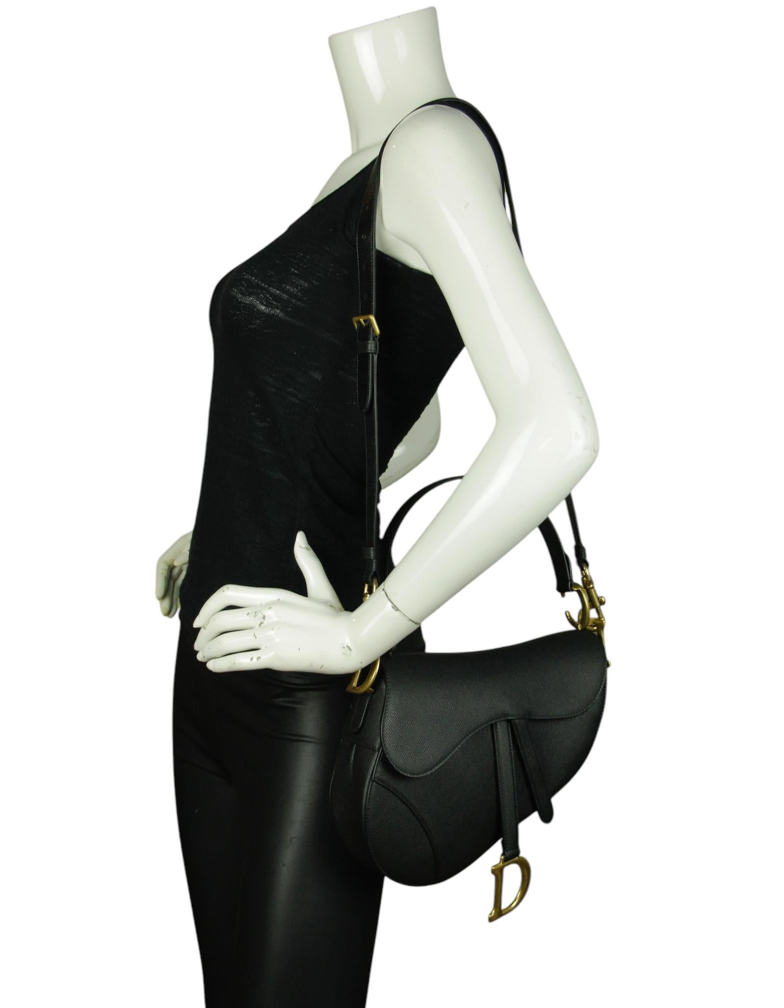 Christian Dior Black Grained Calfskin Saddle Bag With Strap

Made In: Italy
Year of Production: 2023
Color: Black
Hardware: Goldtone
Materials: Grained calfskin leather
Lining: Black suede
Closure/Opening: Top flap with magnetic closure
Exterior