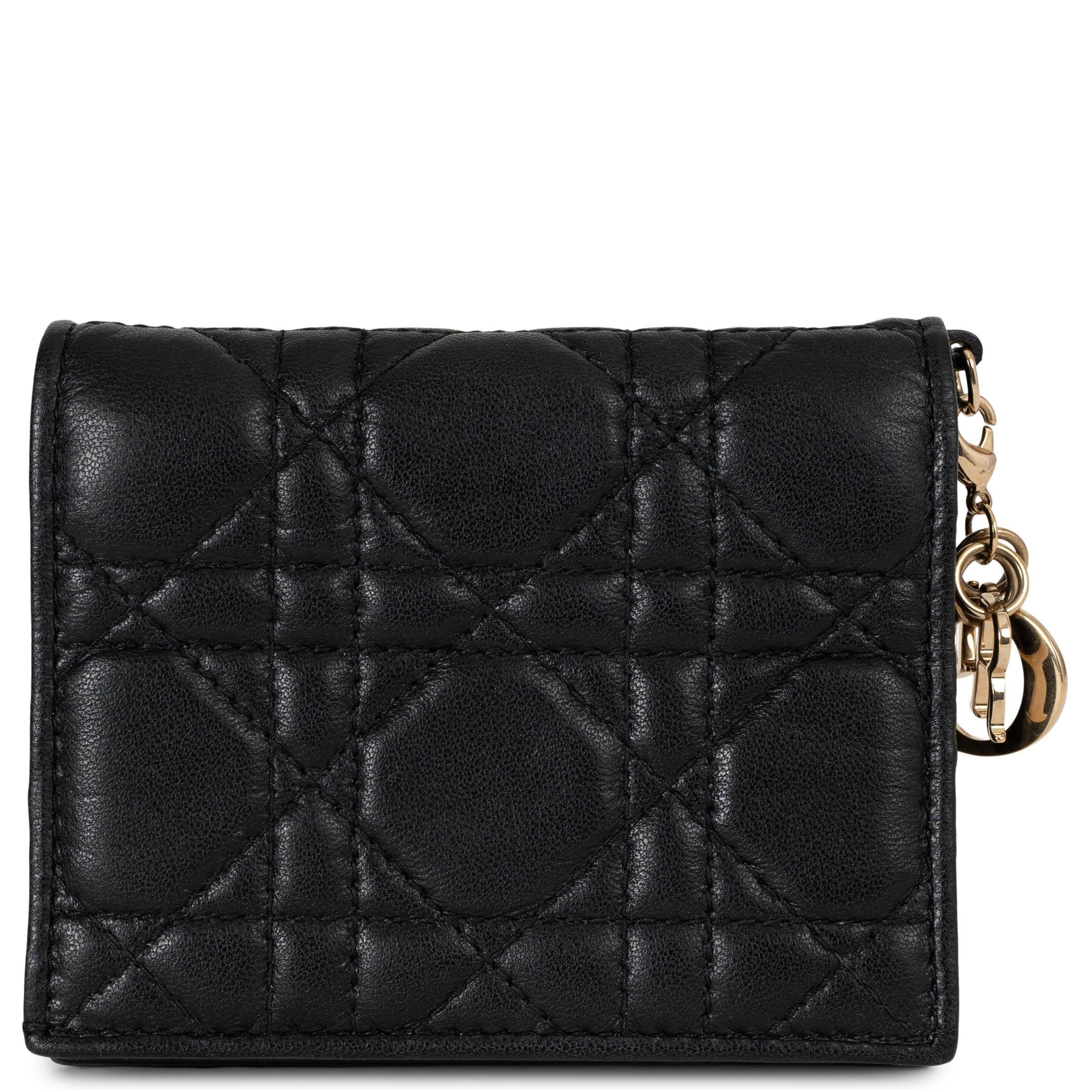 Esta Cartera Mini Lady Dior Gardenia 100% auténtica Christian Dior de piel de cordero Cannage negra es un básico refinado con un toque elegante. Con un colgante D.I.O.R. chapado en oro, irradia una sofisticación atemporal. La cartera se abre con un