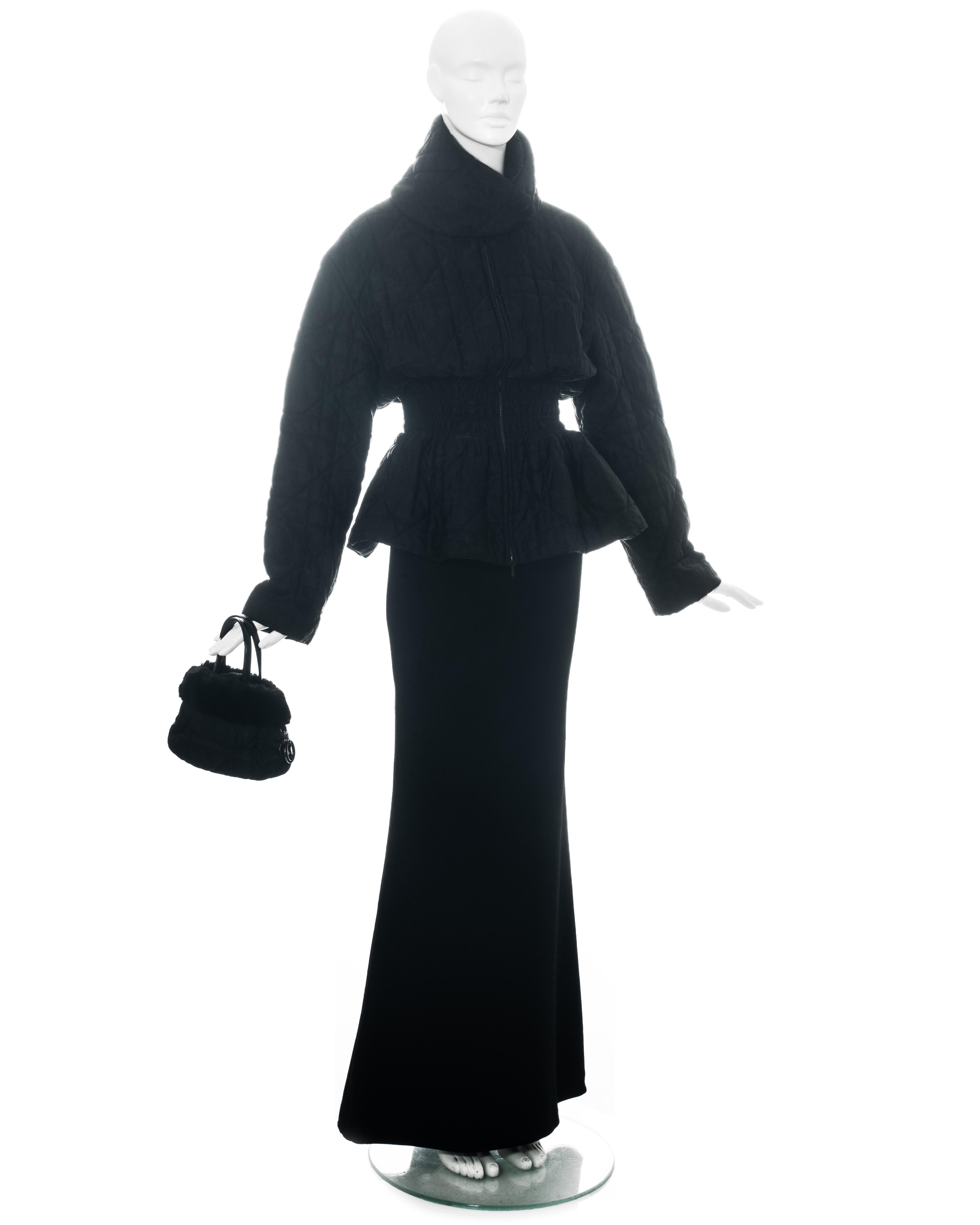 Ensemble noir 3 pièces Christian Dior by John Galliano comprenant : veste en nylon matelassé Monogram avec ceinture froncée, mini-sac à main et mini-sac à dos avec garniture en fourrure et jupe maxi en jacquard de laine. 

Automne-Hiver 1998