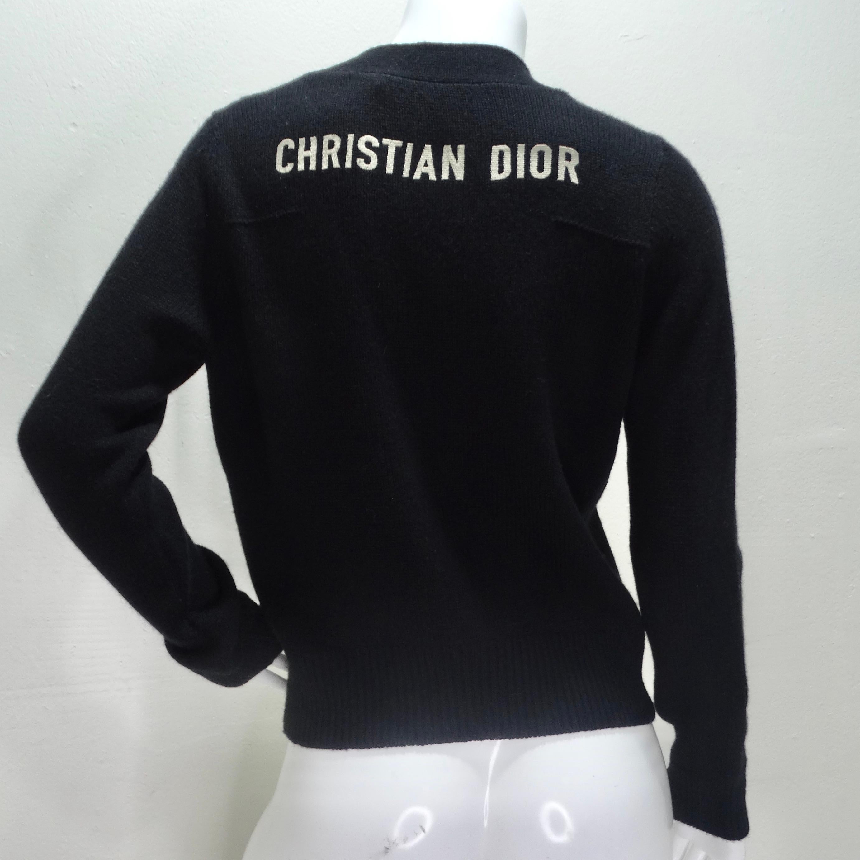 Introducing the Christian Dior Black Cashmere Knit Logo Cardigan – a timeless and versatile piece that exudes luxury and sophistication. Crafted from a sumptuous blend of cashmere and wool, this classic black knit cardigan offers unparalleled