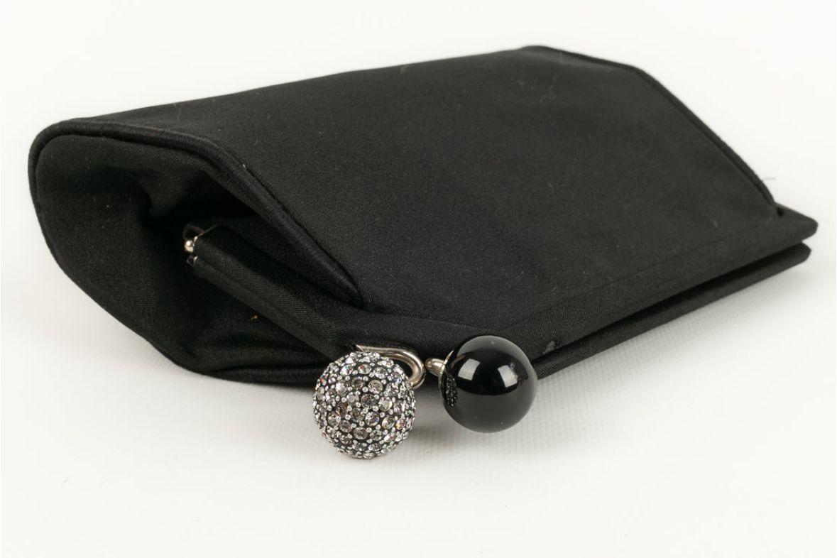 Dior -Black clutch and attributes in silver metal, rhinestones and resin. Presence of small defects on the canvas.

Additional information: 

Dimensions: 
Length: 19 cm, Height: 14 cm, Depth: 3 cm

Condition: 
Good condition
Seller Ref number: S231