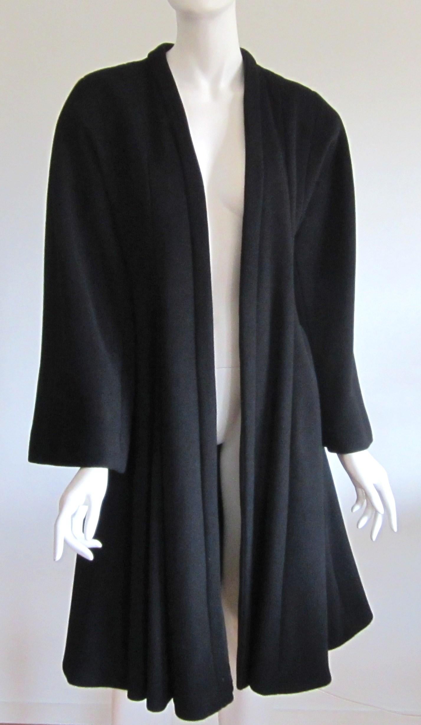 Stunning black wool blend princess coat Dior Coat. In wonderful condition! Labeled Christian Dior Size 38. Coat is a swing style with a great flared bottom. I have used a vintage brooch to keep it closed. I'm including it with the coat. Measuring 