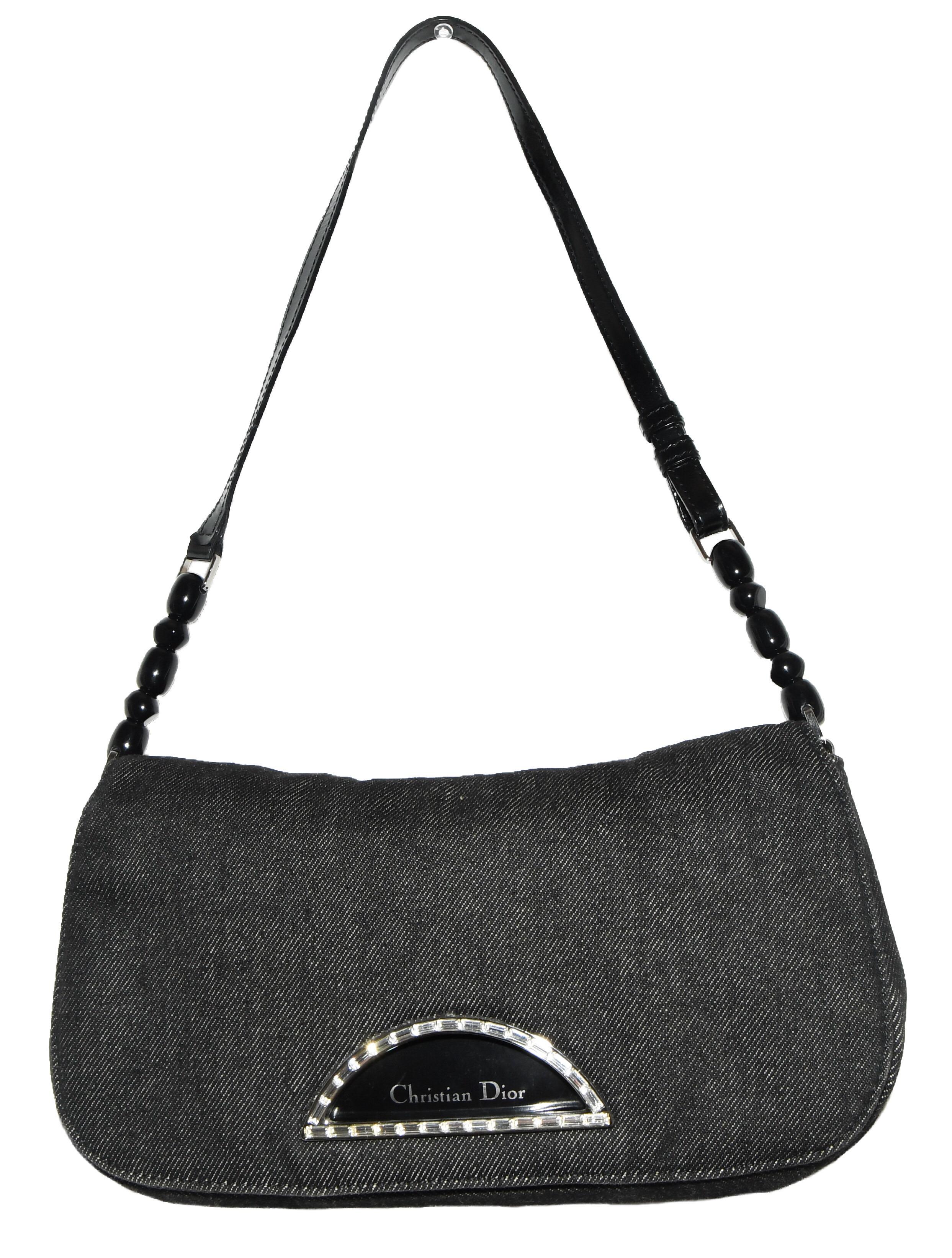 Christian Dior black denim Malice baguette contains silver tone hardware.  This bag includes a black flat leather strap with black  decorative beads.  This front flap bag with magnetic closure under flap and peek a boo opening that is adorned with