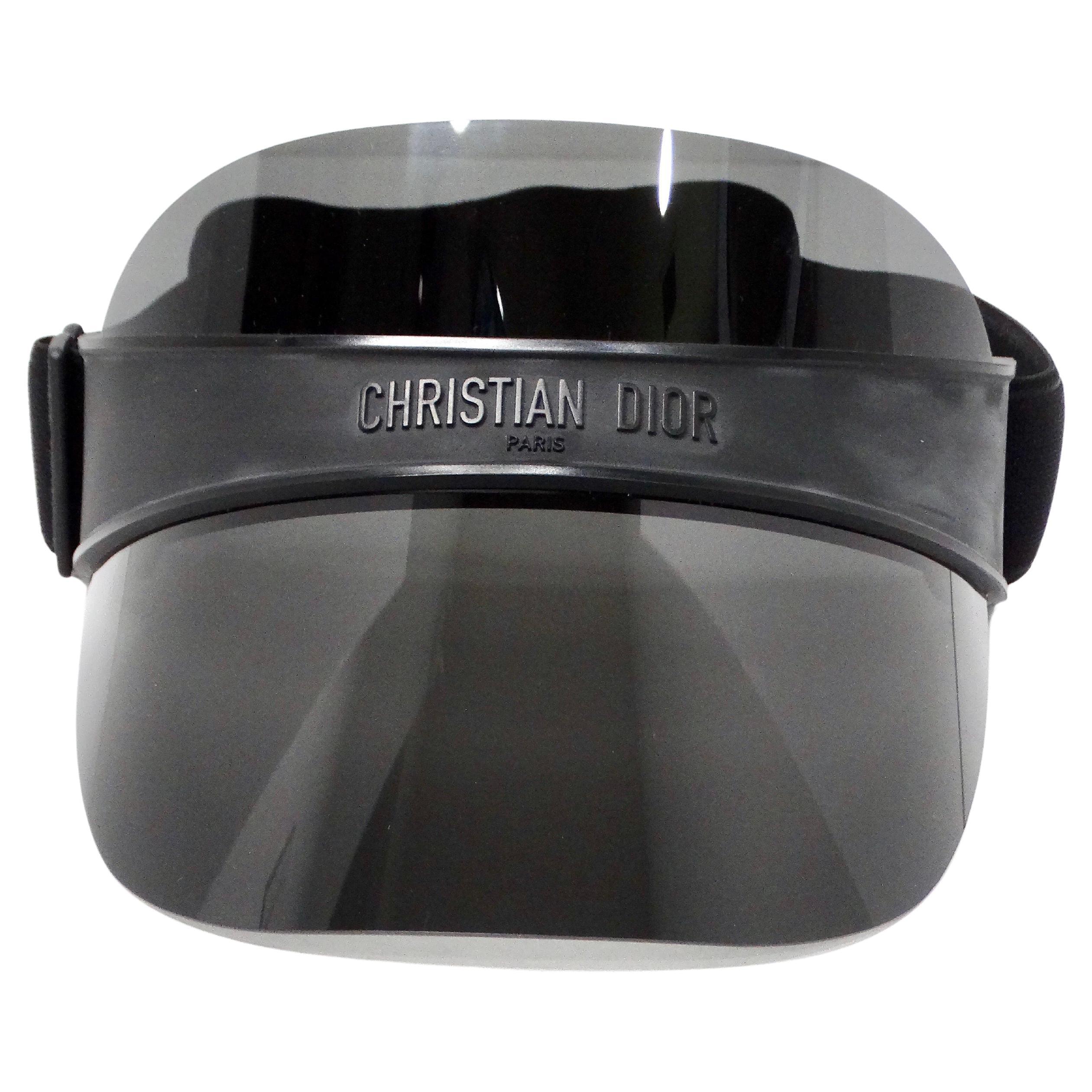 The Christian Dior Black DiorClub V1U Mirrored Sun Visor is a striking accessory that combines luxury fashion with practical sun protection. Crafted with meticulous attention to detail, this visor features a sleek black finish complemented by a