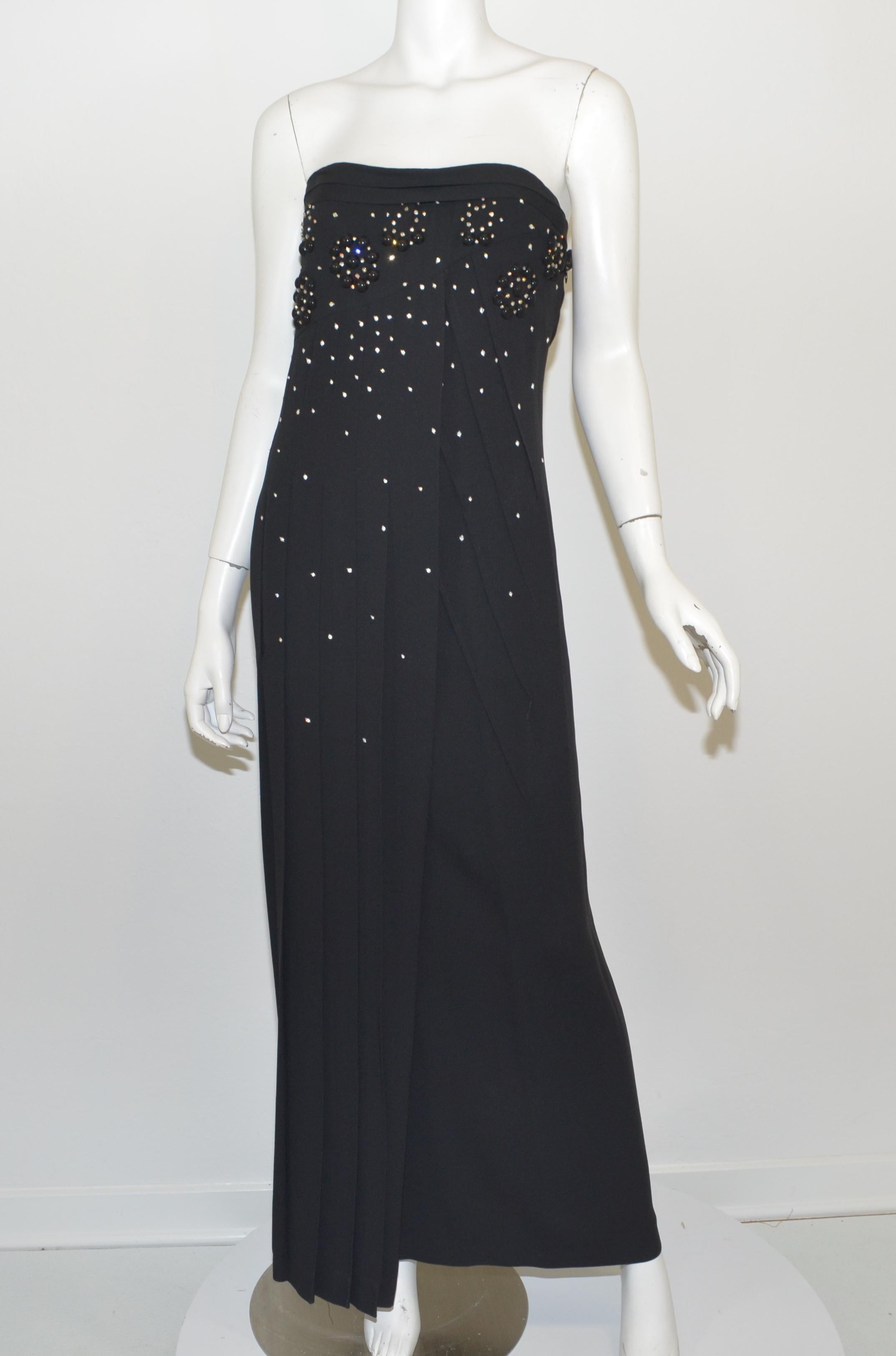 Black crepe, column dress with black beads and rhinestone embellishing along the bust and bodice, front of the dress has a pin-tucked/pleated design with a side zipper closure and a built in, boned bustier bra. 

Measurements:
Bust 26”
Waist